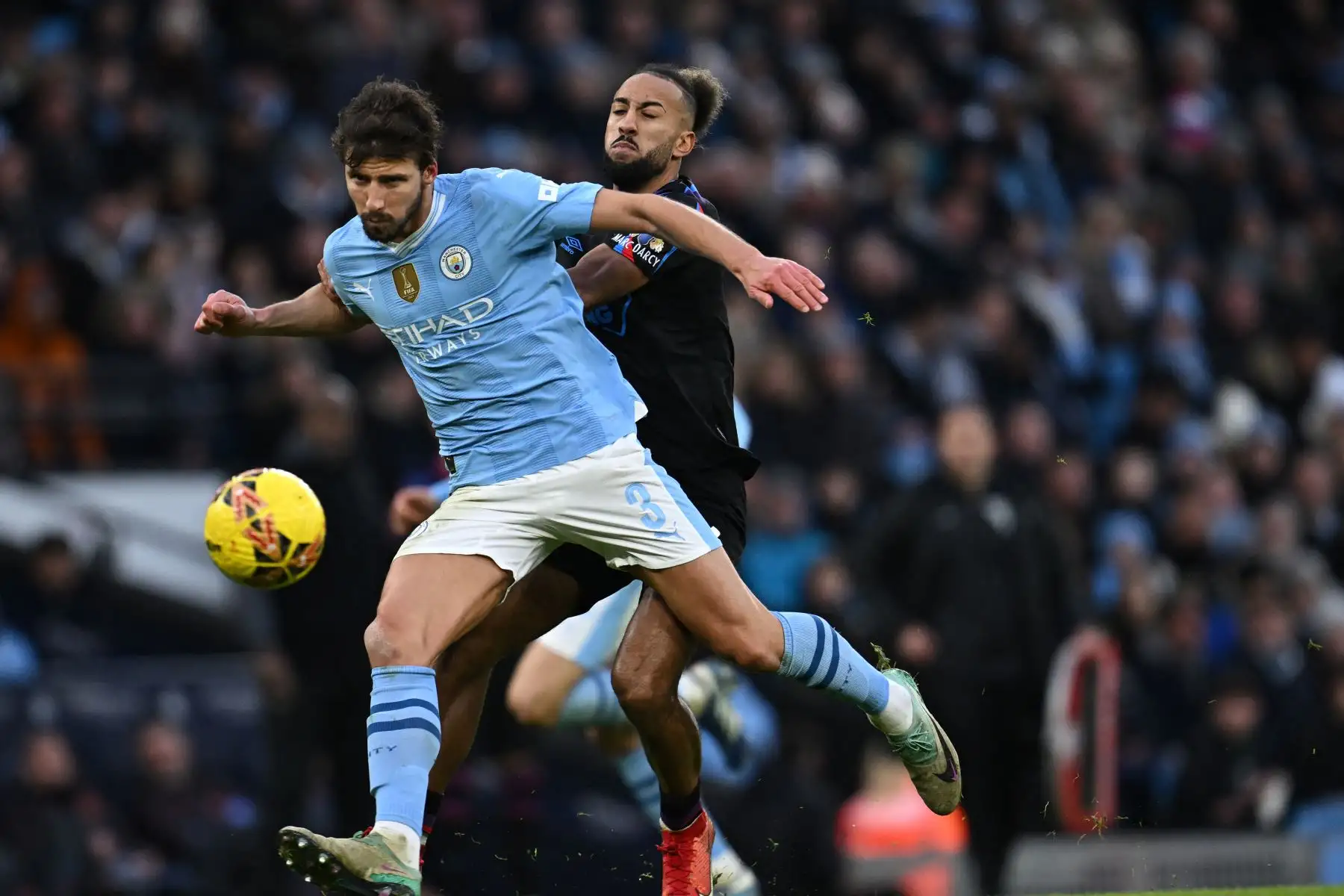 El defensor portugués del Manchester City Ruben Dias compite con el centrocampista galés del Huddersfield Town Sorba Thomas durante el partido de fútbol de la tercera ronda de la Copa FA inglesa entre Manchester City y Huddersfield Town en el estadio Etihad de Manchester, noroeste de Inglaterra. Foto : ANDINA/AFP