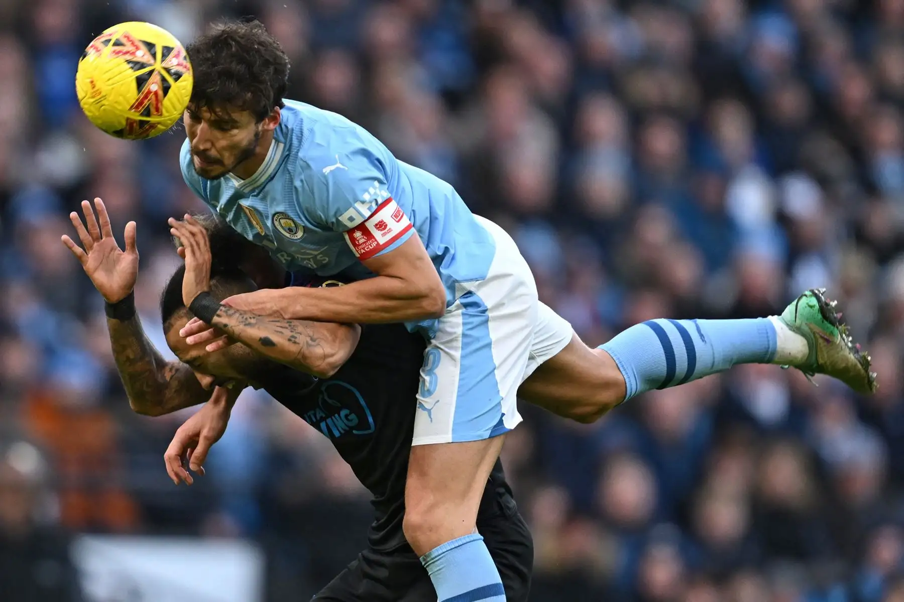 El defensor portugués del Manchester City Ruben Dias gana un encabezado del centrocampista galés de Huddersfield Town Sorba Thomas durante el partido de fútbol de la tercera ronda de la Copa FA inglesa entre Manchester City y Huddersfield Town en el estadio Etihad de Manchester, al noroeste Inglaterra. Foto: ANDINA/AFP