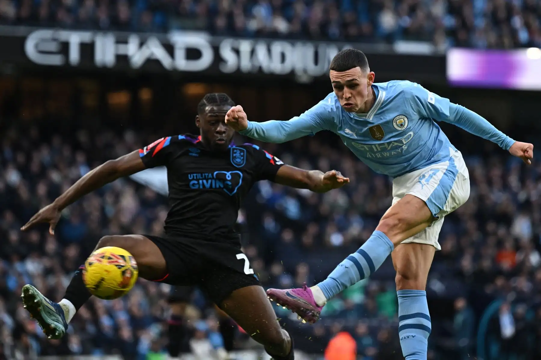 El centrocampista inglés del Manchester City  Phil Foden dispara para marcar el gol inicial del partido de fútbol de la tercera ronda de la Copa FA inglesa entre Manchester City y Huddersfield Town en el estadio Etihad de Manchester, noroeste de Inglaterra. Foto: ANDINA/AFP