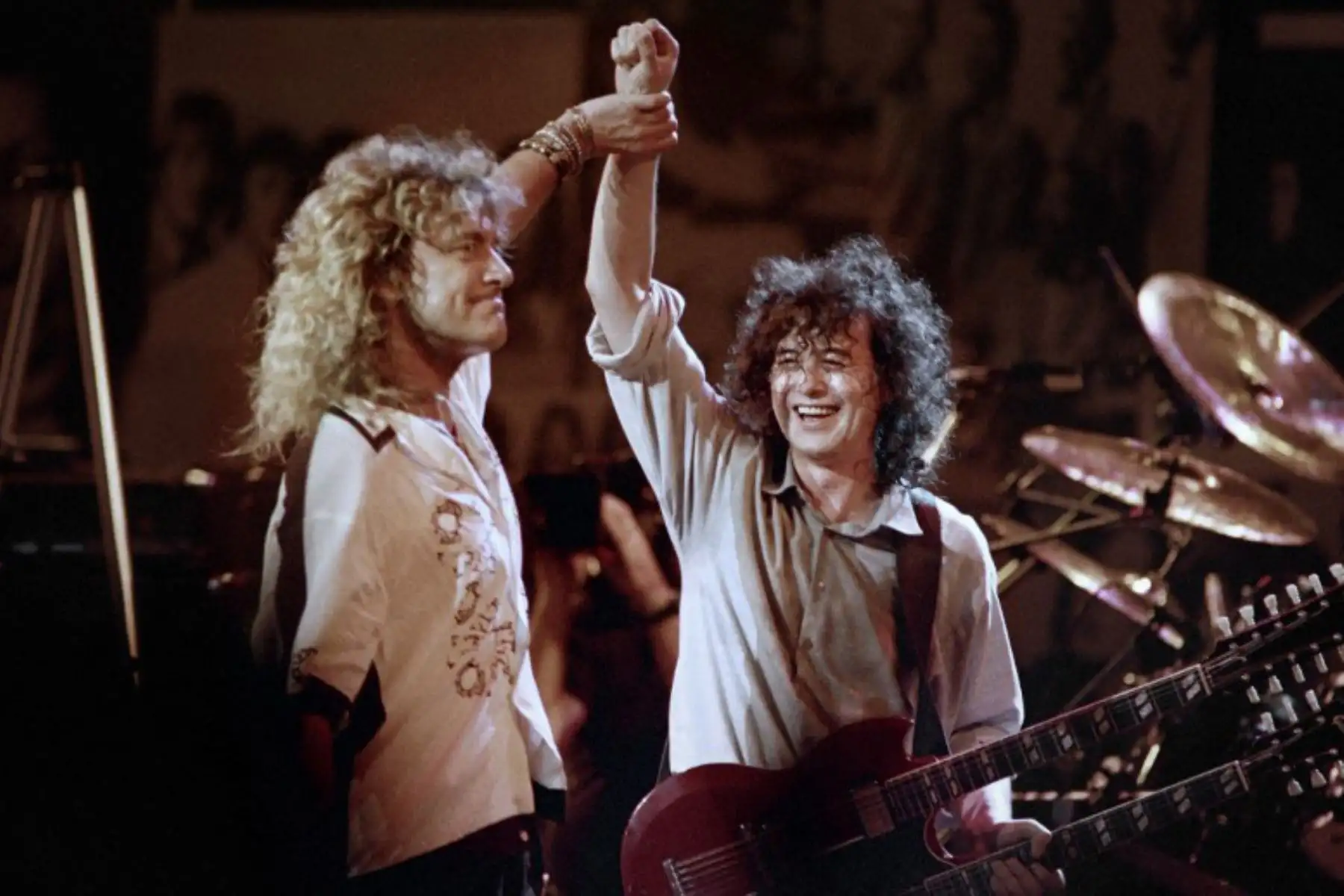 El cantante británico Robert Plant, sostiene las manos en alto con el guitarrista británico Jimmy Page durante una reunión de Led Zeppelin en el Madison Square Garden de Nueva York el 14 de mayo de 1988. Foto: AFP
