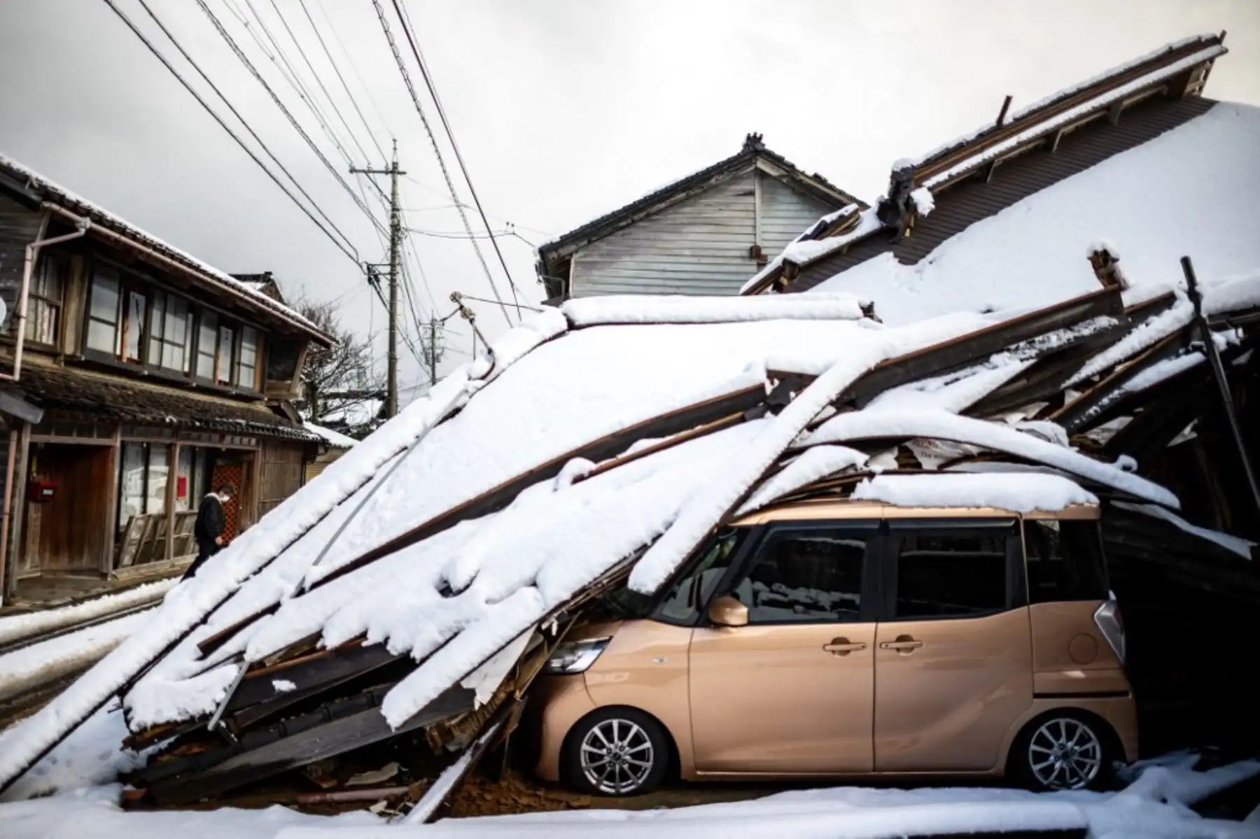 Un automóvil dañado yace debajo de un edificio derrumbado en la ciudad de Shika en el distrito de Hakui, prefectura de Ishikawa, el 8 de enero de 2024, después de que un gran terremoto de magnitud 7,5 sacudiera la región de Noto el día de Año Nuevo. Foto: AFP
