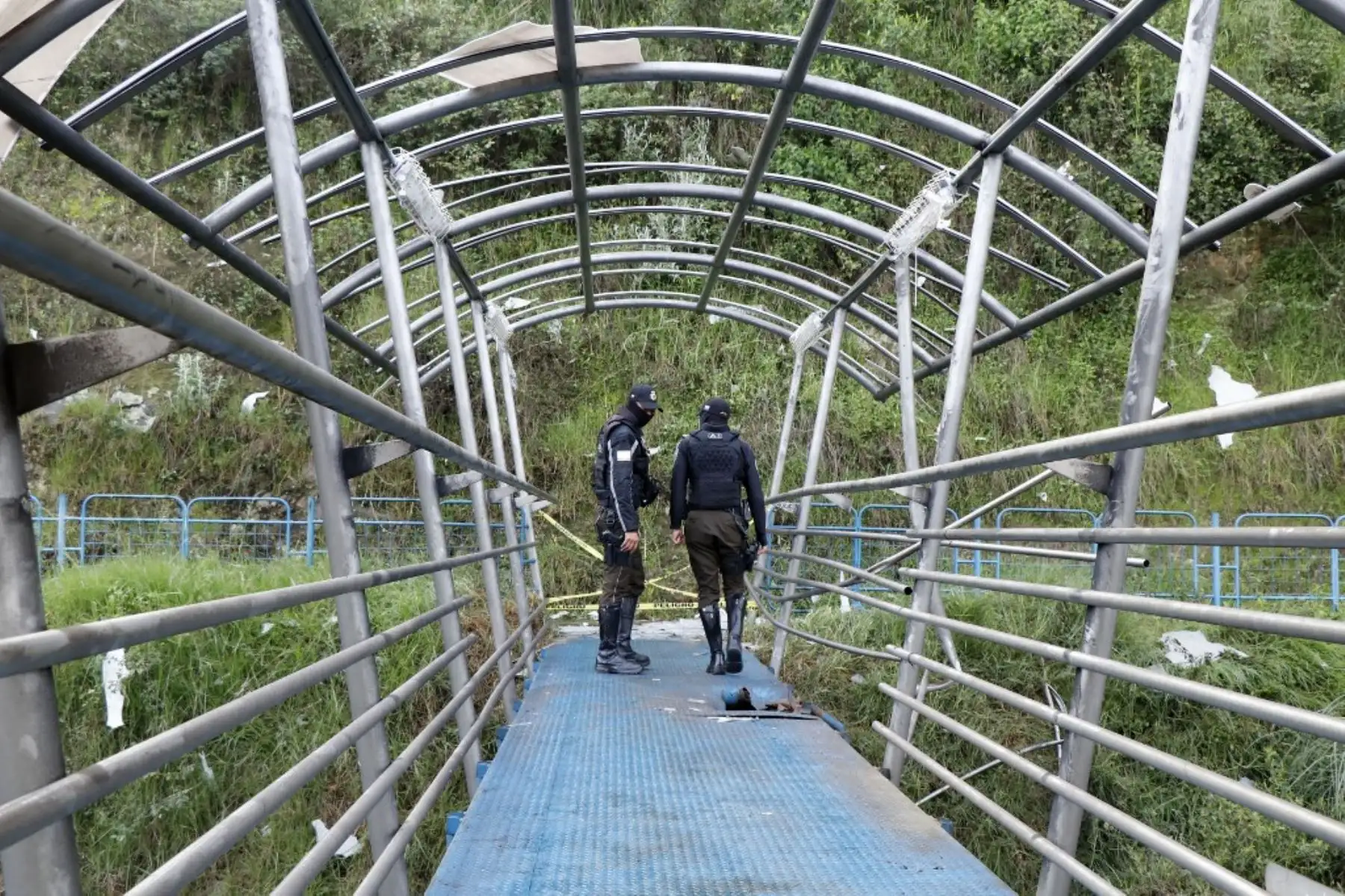 Agentes de policía inspeccionan un puente peatonal dañado por una explosión sobre la carretera General Rumiñahui en el sector Monjas de Quito, el 9 de enero de 2024, un día después de que el presidente ecuatoriano Daniel Noboa declarara el estado de emergencia tras la fuga de prisión de un peligroso jefe narco. Foto: AFP