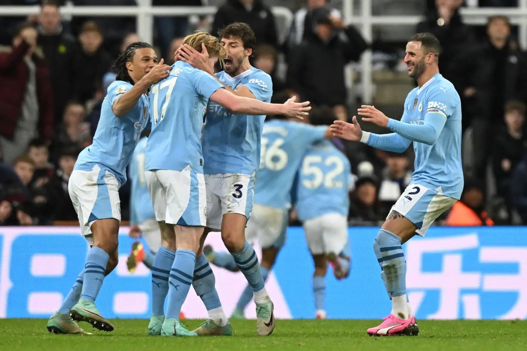 El centrocampista belga del Manchester City,  Kevin De Bruyne es felicitado por sus compañeros de equipo después de jugar un pase para su último gol ganador durante el partido de fútbol de la Liga Premier inglesa entre Newcastle United y Manchester City en St James