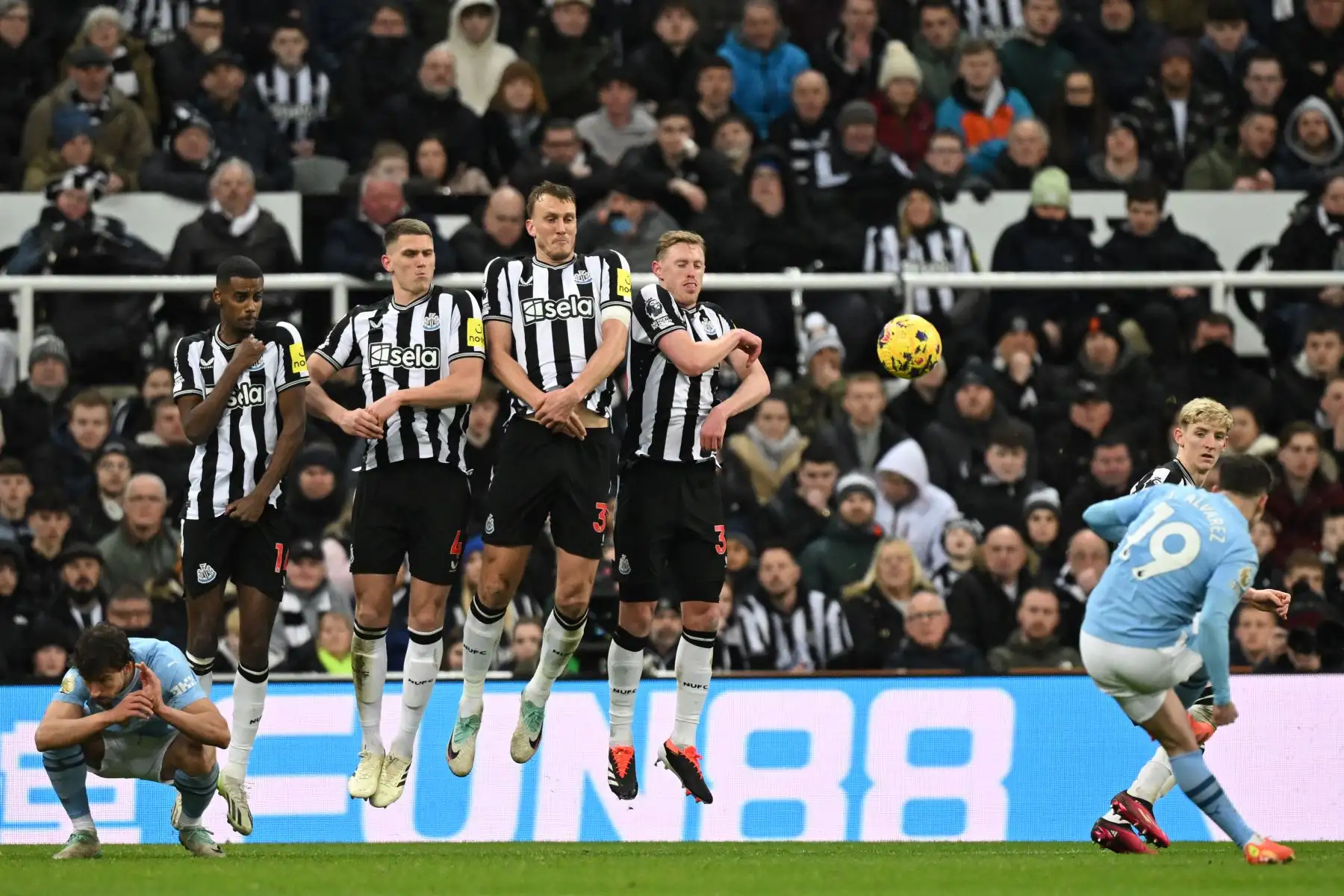 El muro defensivo de Newcastle salta para bloquear un tiro libre del delantero argentino del Manchester City, Julian Alvarez durante el partido de fútbol de la Premier League inglesa entre Newcastle United y Manchester City en St James