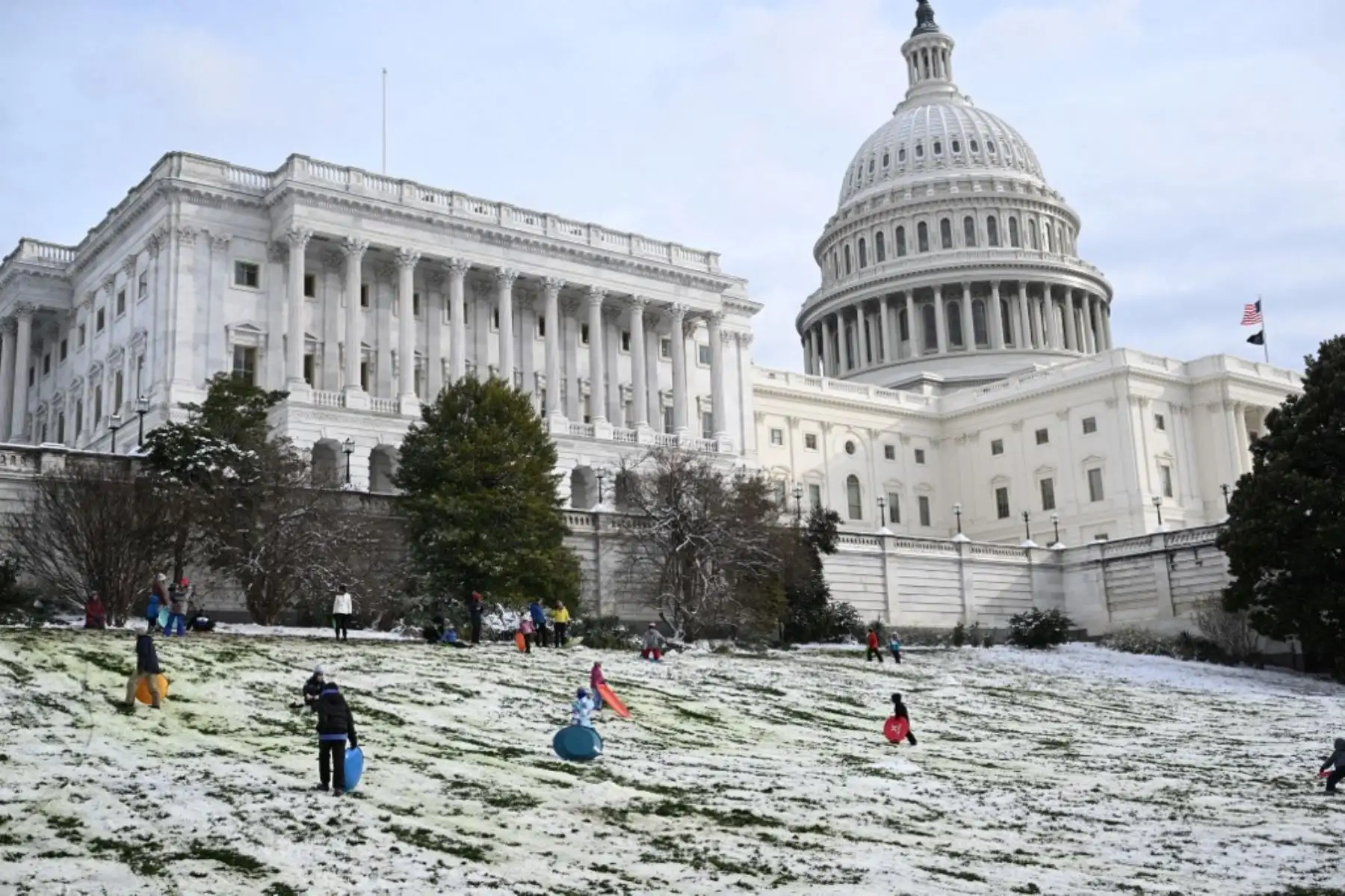 Personas llevan trineos  junto al Capitolio de los Estados Unidos en Washington DC. Foto: AFP