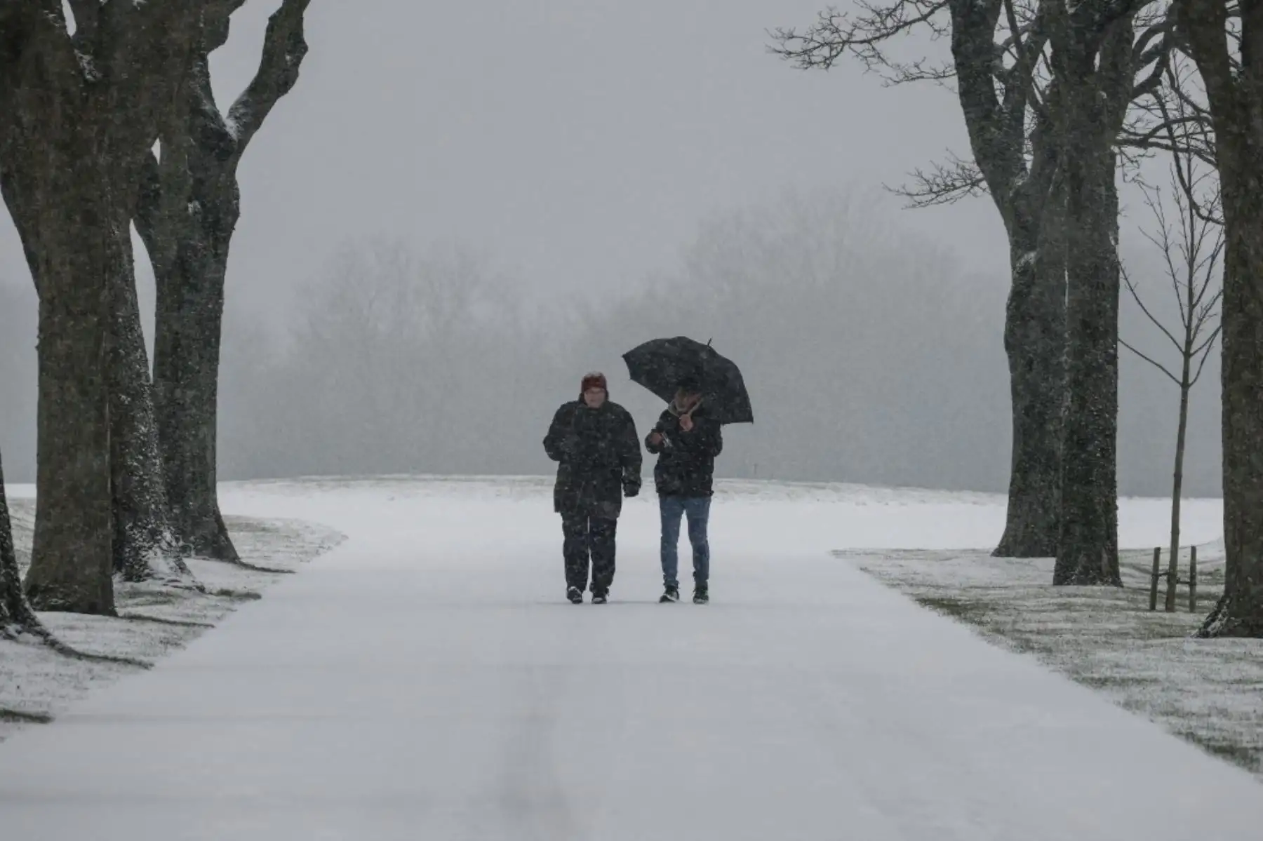 Dos personas caminan sobre la nieve en la ciudad de Vimy, al norte de Francia, el 17 de enero de 2024. Lluvias heladas azotaron el norte y el este de Francia la mañana del 17 de enero, dificultando el tráfico. Foto: AFP