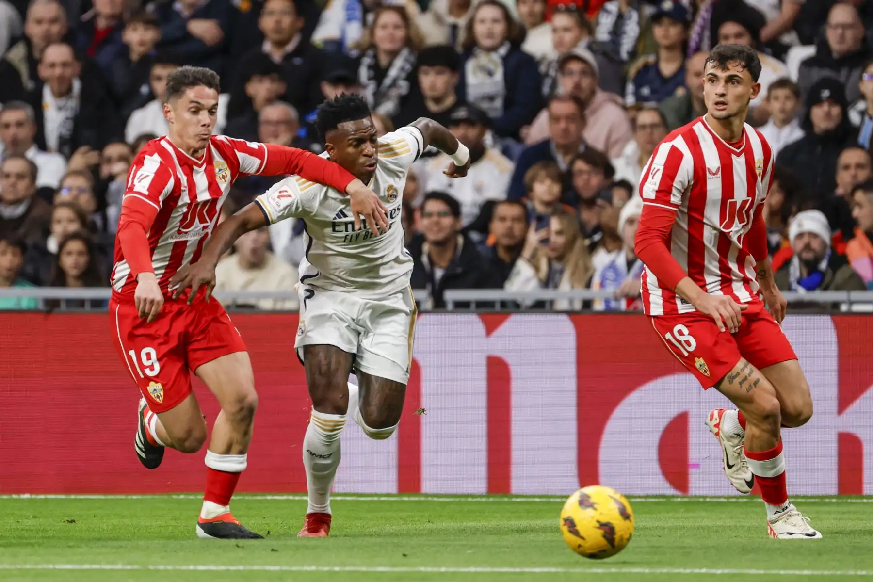 El delantero brasileño del Real Madrid Vinícius Júnior disputa un balón ante los jugaodres de la UD Almería Marc Pubill y Sergio Arribas durante el partido de LaLiga correspondiente a la jornada 21, y que enfrenta este domingo a Real Madrid y UD Almería en el Santiago Bernabéu. Foto: ANDINA/EFE