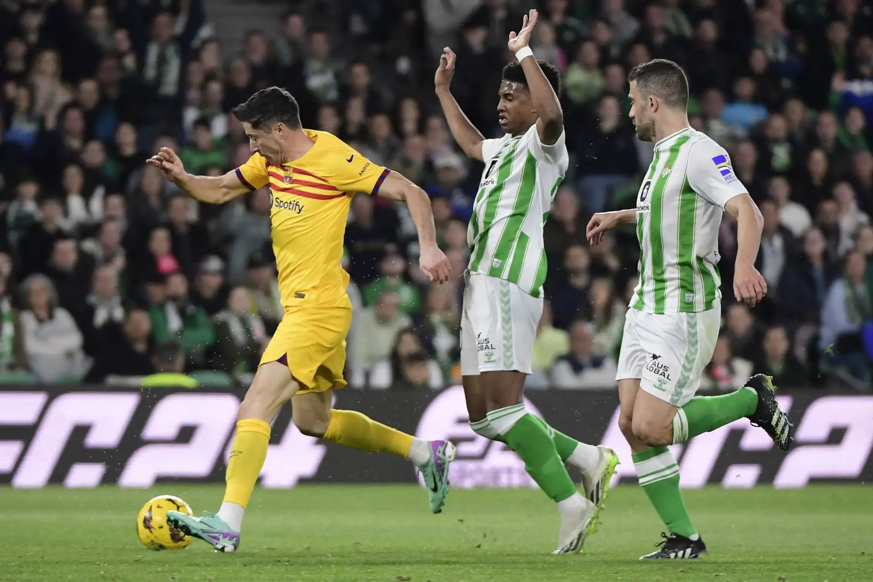 El delantero polaco del Barcelona Robert Lewandowski dribla el balón junto al centrocampista español del Real Betis Assane Diao durante el partido de fútbol de la Liga española entre el Real Betis y el FC Barcelona. Foto: ANDINA/AFP