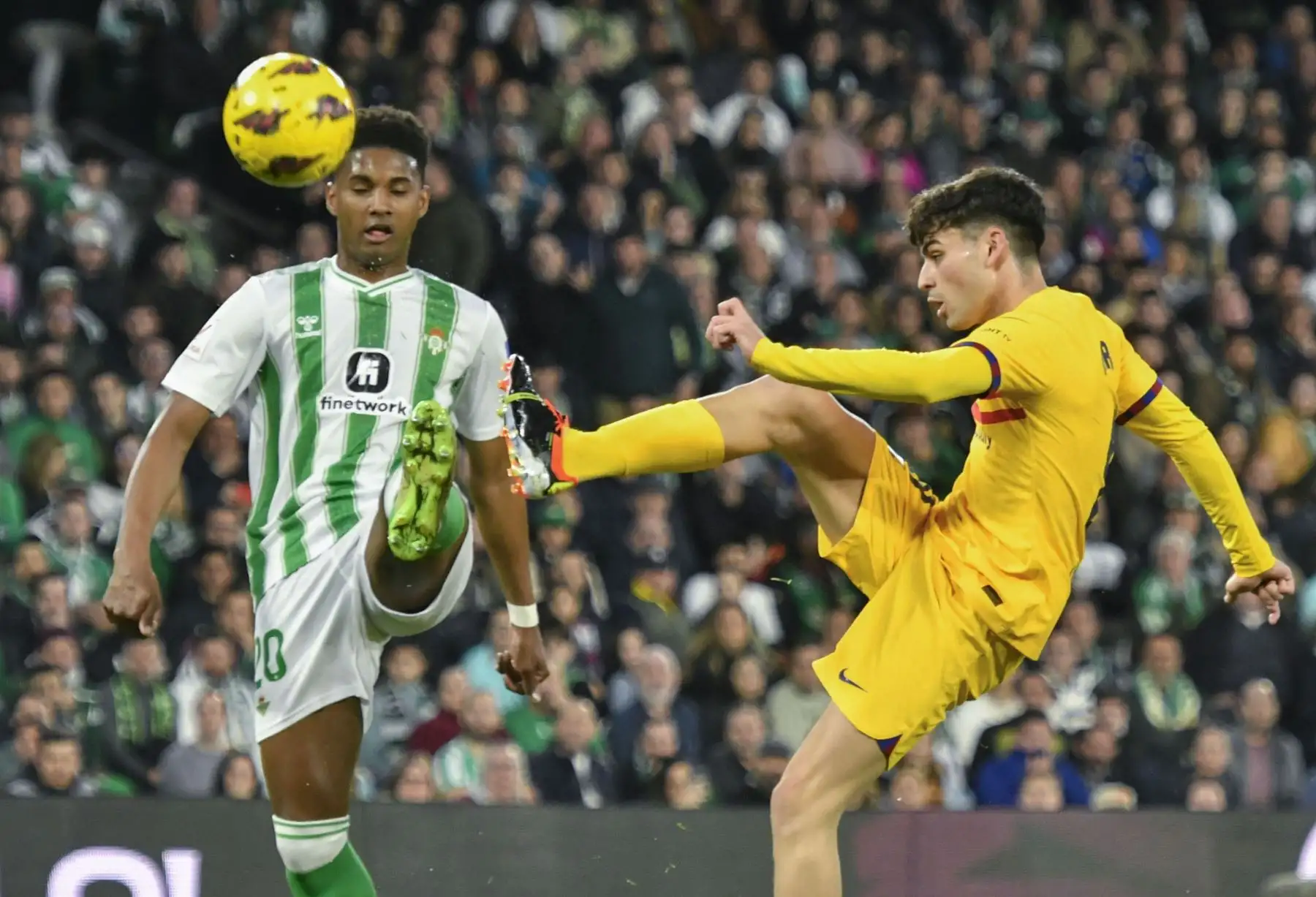 El centrocampista del FC Barcelona, Pedri, golpea el balón ante el defensa brasileño del Betis, Abner, durante el encuentro correspondiente a la jornada 21 de Primera División que Betis y FC Barcelona. Foto: ANDINA/ EFE