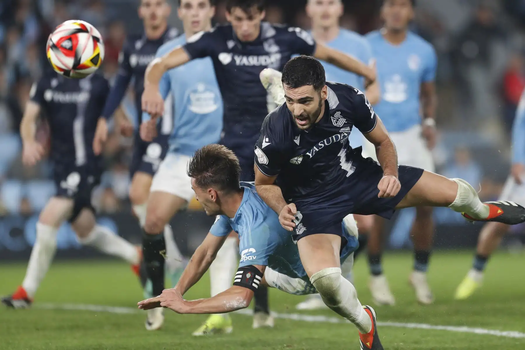 El defensa del Celta de Vigo Kevin (i) pugna por el balón con Mikel Merino, de la Real Sociedad, durante el partido de cuartos de final de la Copa del Rey que Celta de Vigo y Real Sociedad disputan este martes en Balaídos, Vigo (Galicia). 
Foto: EFE
