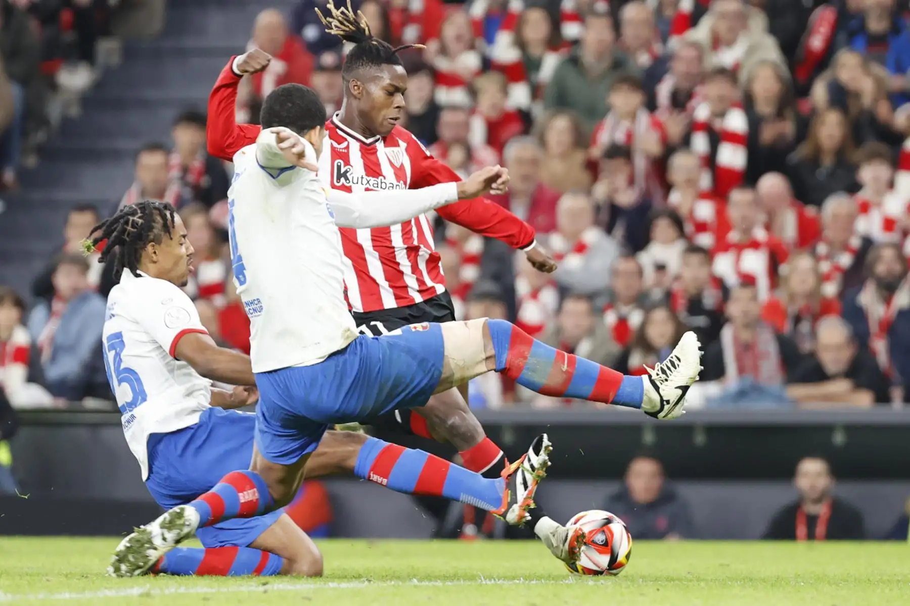 El delantero del Athletic Nico Williams lucha con el uruguayo Ronald Araújo y con el francés Jules Koundé, ambos del FC Barcelona, durante el partido de los cuartos de final de la Copa del Rey de fútbol que Athletic Club y FC Barcelona disputan este miércoles en el estadio de San Mamés.
Foto: EFE