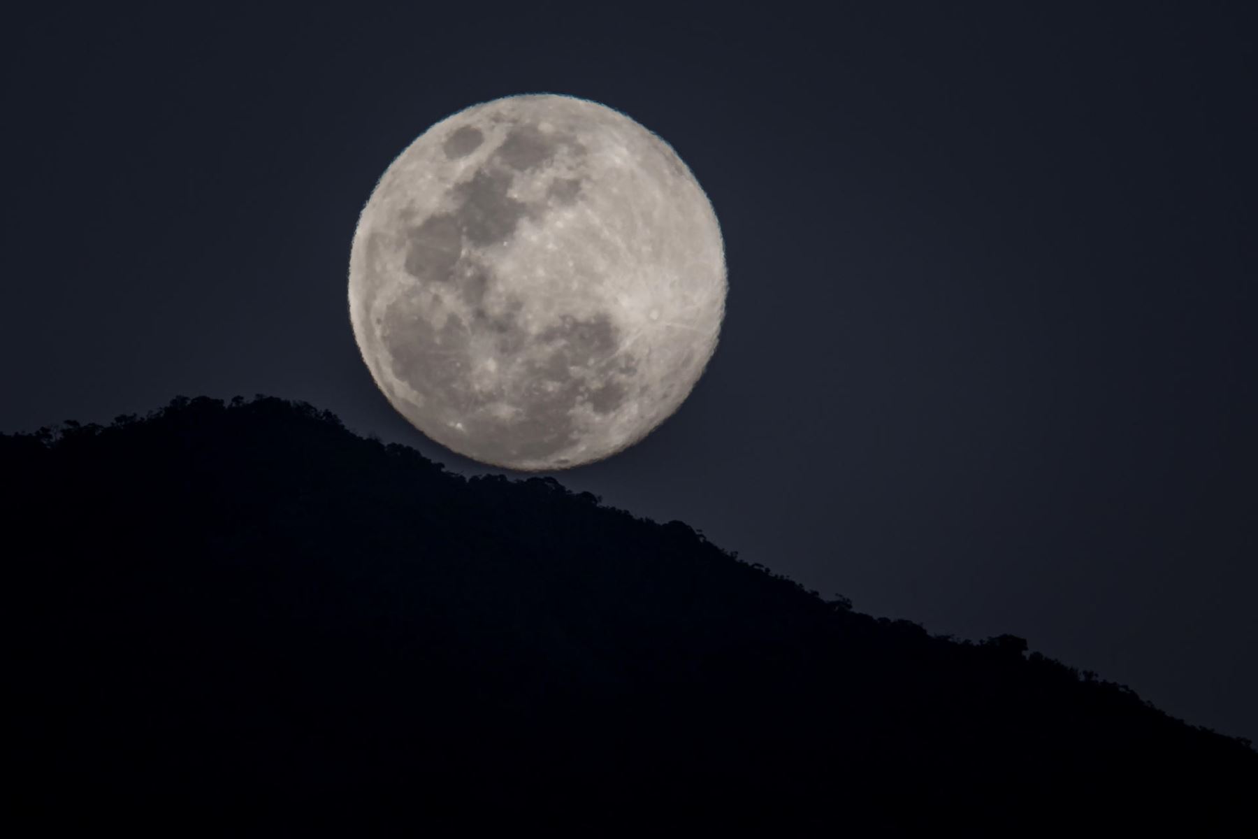 Vista hoy de la luna llena detrás del Parque Nacional Waraira Repano, conocido como Cerro El Ávila, en Caracas (Venezuela).
Foto: EFE