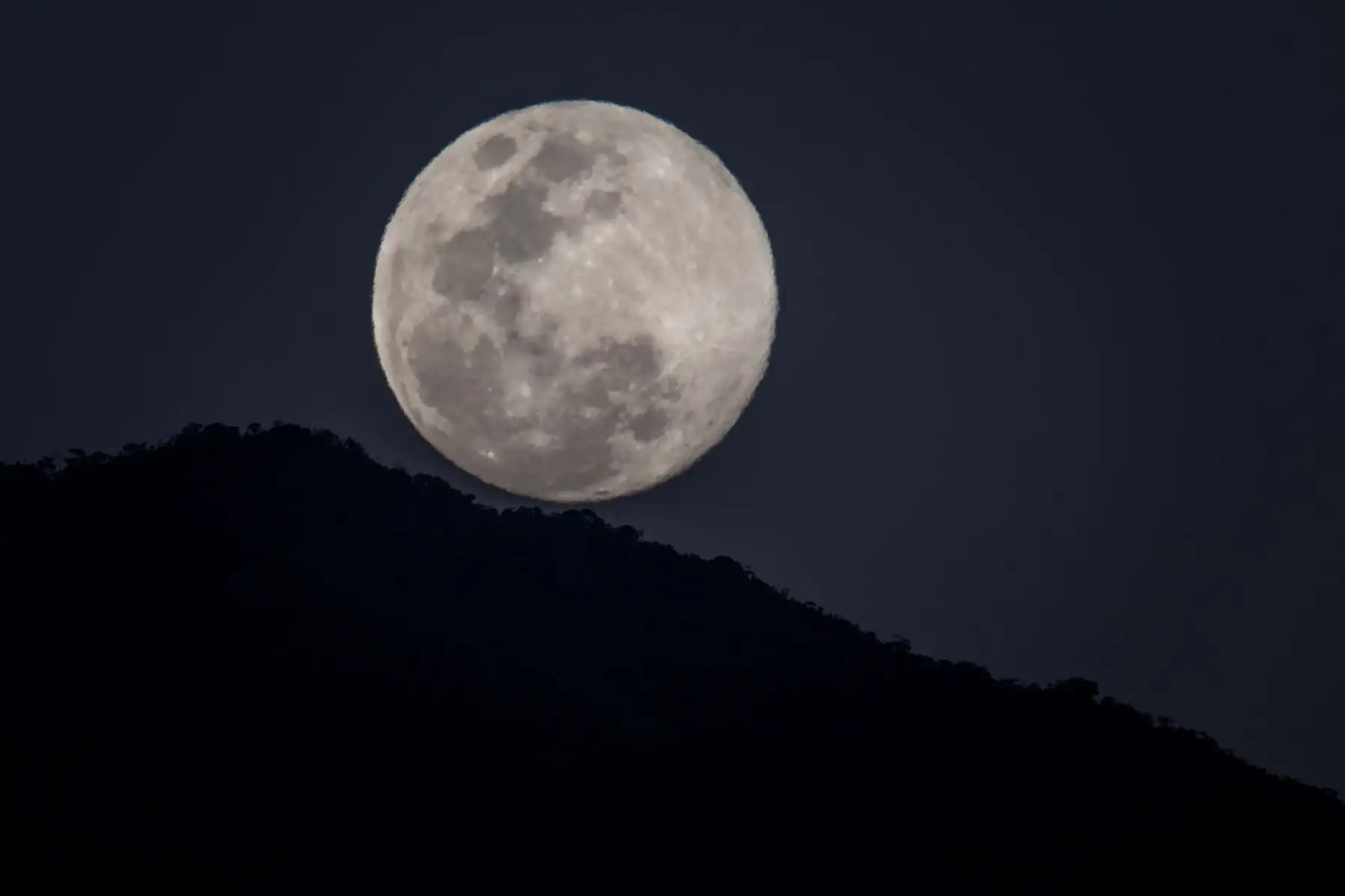 Vista hoy de la luna llena detrás del Parque Nacional Waraira Repano, conocido como Cerro El Ávila, en Caracas (Venezuela).
Foto: EFE