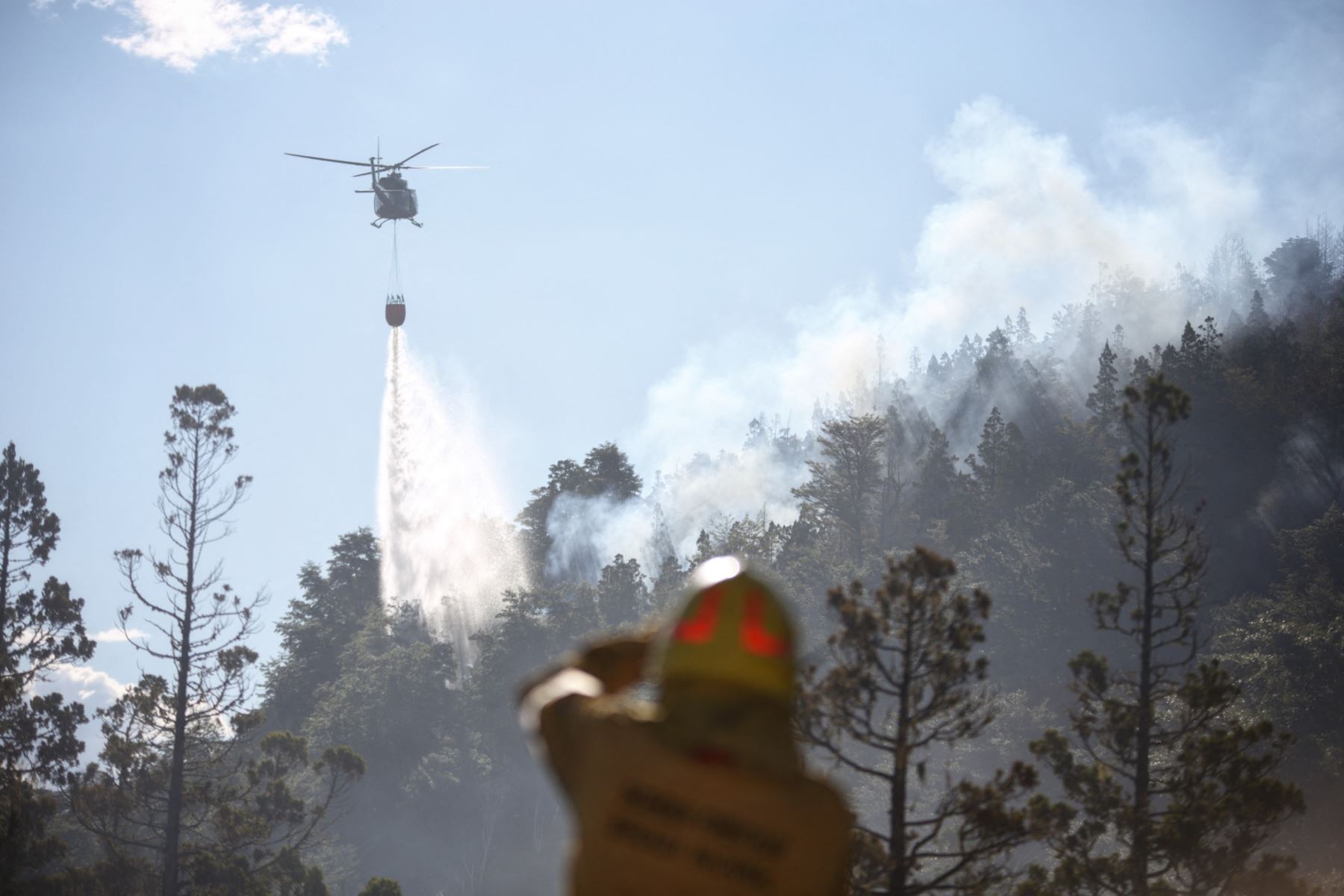Esta imagen publicada por Parques Nacionales de Argentina a través de Télam muestra un helicóptero arrojando agua para apagar un incendio forestal en el Parque Nacional Los Alerces en la provincia de Chubut, Argentina, el 26 de enero de 2024. Foto: AFP