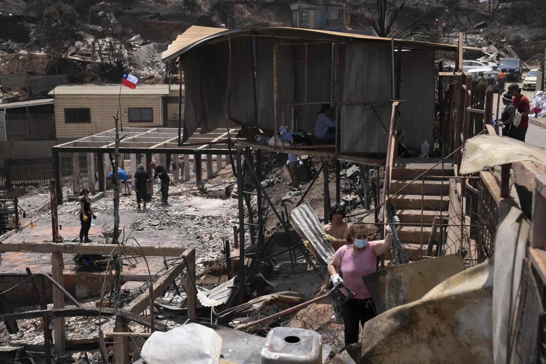 Personas retiran escombros desde una casa en el sector de Achupallas afectada por incendios forestales de Viña del Mar, Región de Valparaiso (Chile). Las autoridades chilenas informaron este domingo de que el número de muertos en los devastadores incendios que han consumido grandes sectores de viviendas en la región de Valparaíso, a 100 kilómetros al este de Santiago, aumentó a 99, aunque se espera que siga creciendo con las horas
Foto: EFE