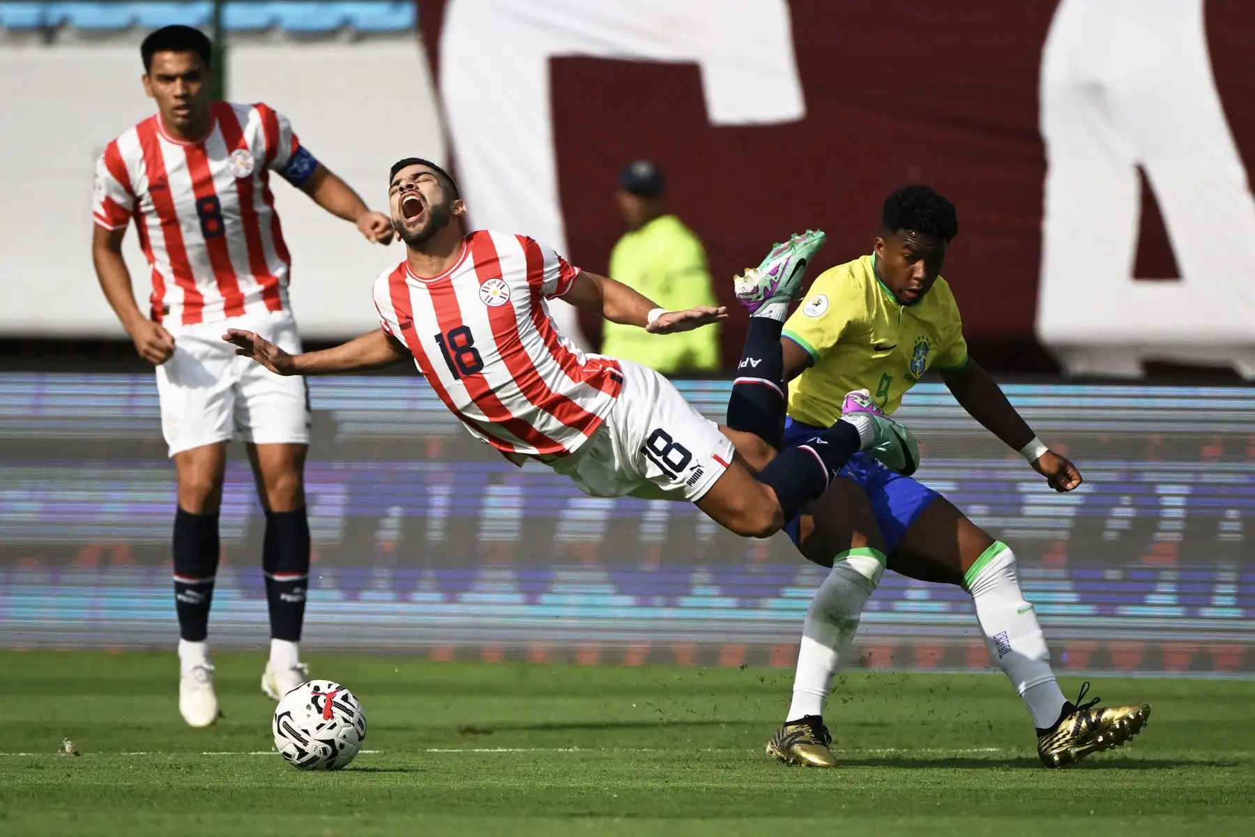 El brasileño Endrick  comete falta sobre el paraguayo Leonardo Rivas durante el partido de fútbol del Torneo Preolímpico CONMEBOL Venezuela 2024 entre Brasil y Paraguay en el estadio Brígido Iriarte de Caracas. Foto. ANDINA/AFP