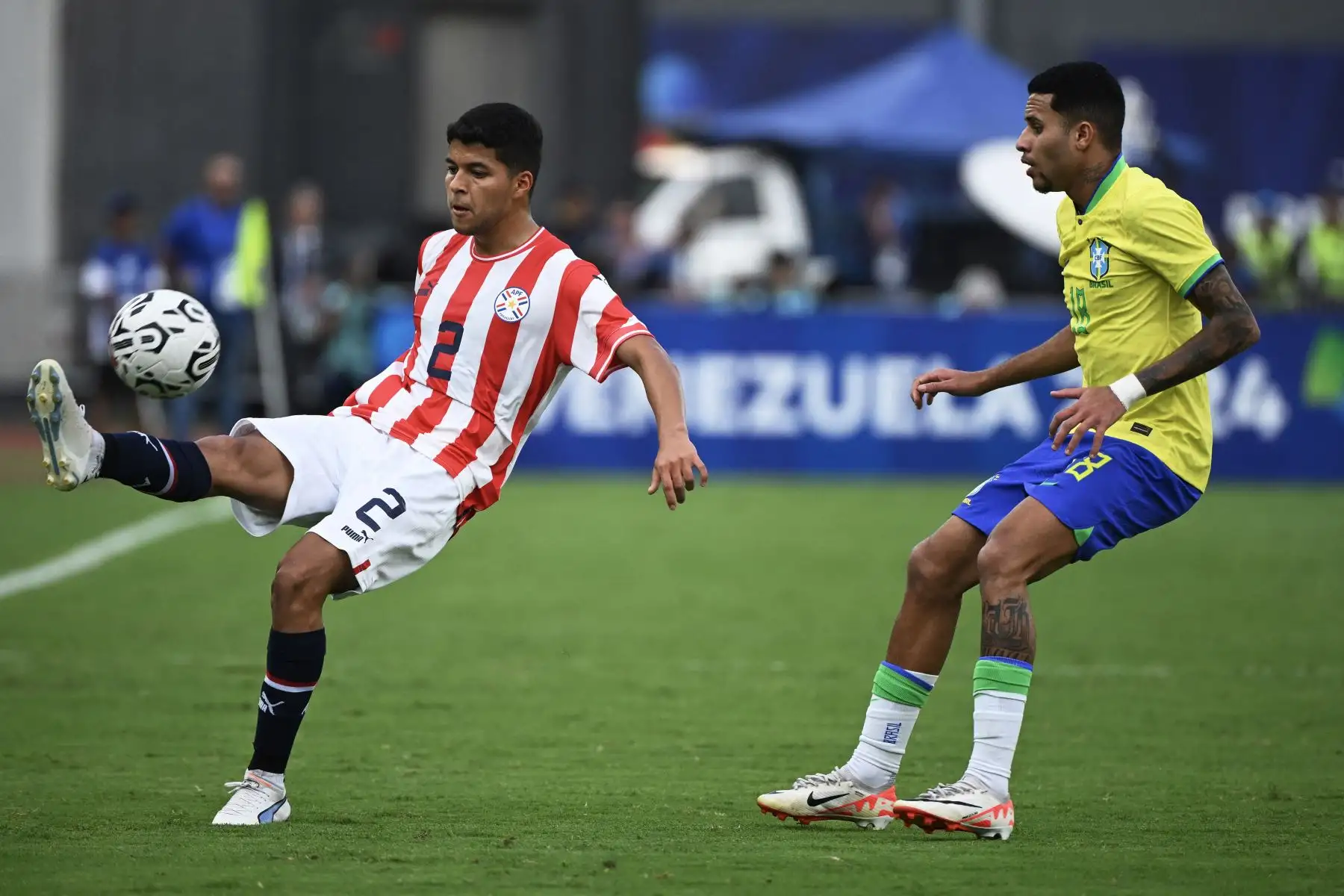 Alan Nuñez de Paraguay y Alexsander de Brasil luchan por el balón durante el partido de fútbol del Torneo Preolímpico CONMEBOL Venezuela 2024 entre Brasil y Paraguay en el estadio Brígido Iriarte de Caracas. Foto. ANDINA/AFP