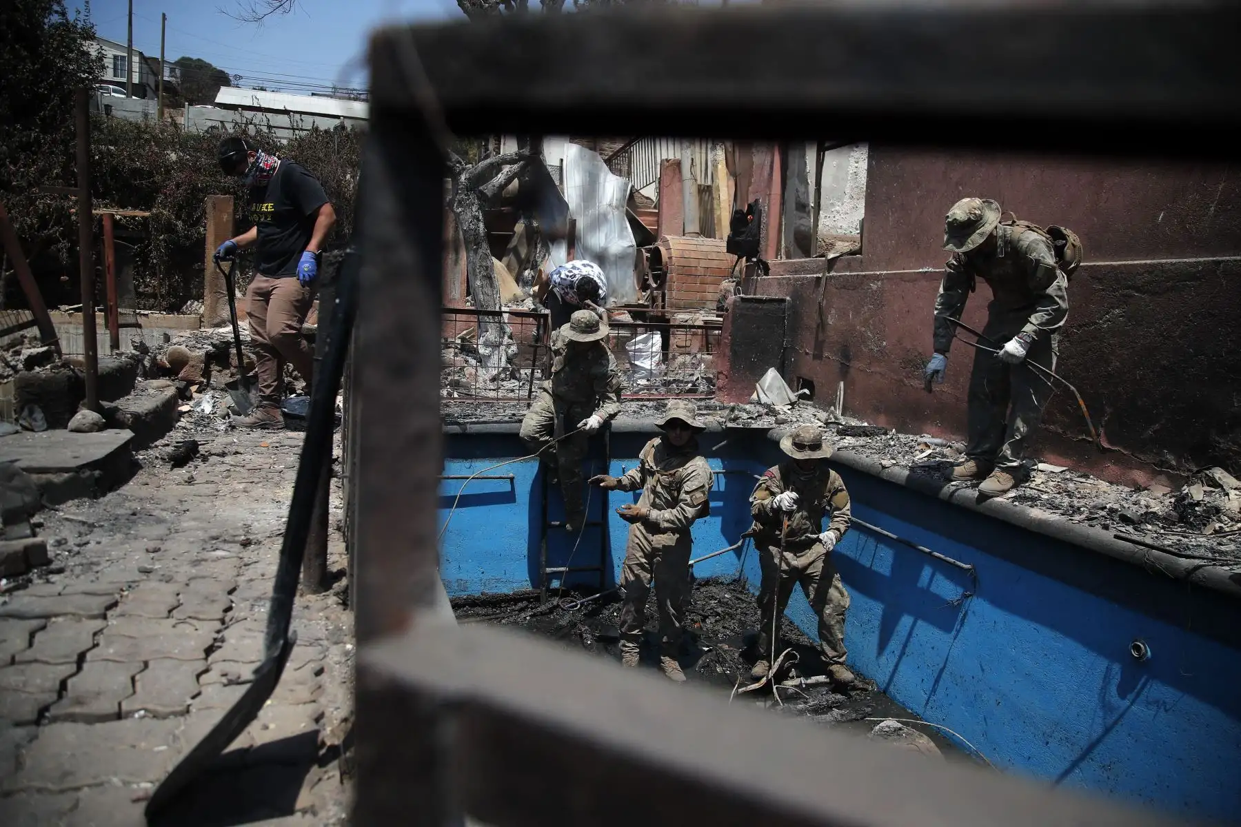 Miembros de la Armada de Chile ayudan en la limpieza de casas quemadas en Villa Independencia, región de Valparaíso. El número de muertos por los incendios forestales en el centro de Chile aumentó a al menos 112 personas el domingo, después de que el presidente Gabriel Boric advirtiera el número aumentaría "significativamente" a medida que los equipos busquen en los barrios destruidos. Foto: ANDINA/AFP