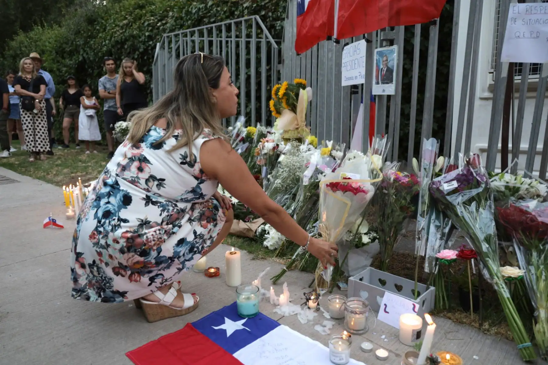 Chilenos dejan ofrendas florales y simbólicas a la entrada de la casa del expresidente chileno Sebastián Piñera hoy, en la comunidad Las Condes en Santiago. El expresidente de Chile Sebastian Piñera murió este martes al estrellarse el helicóptero que al parecer pilotaba sobre el Lago Rengo, en el sur del país, informó su oficina. Foto: ANDINA/EFE
