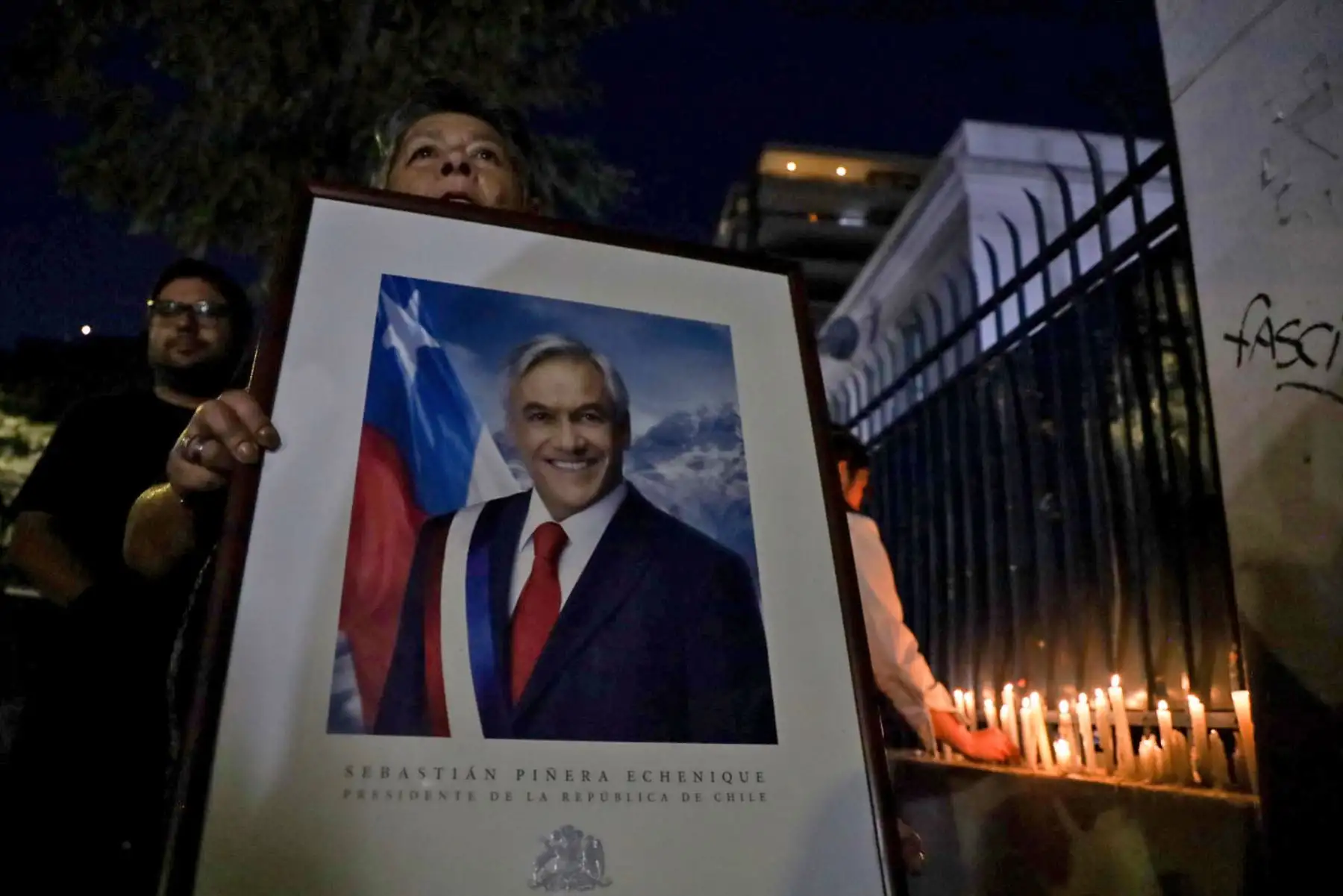 Militantes de Renovacion Nacional encienden velas en la sede del partido en apoyo al expresidente de Chile Sebastían Piñera. Foto: AFP