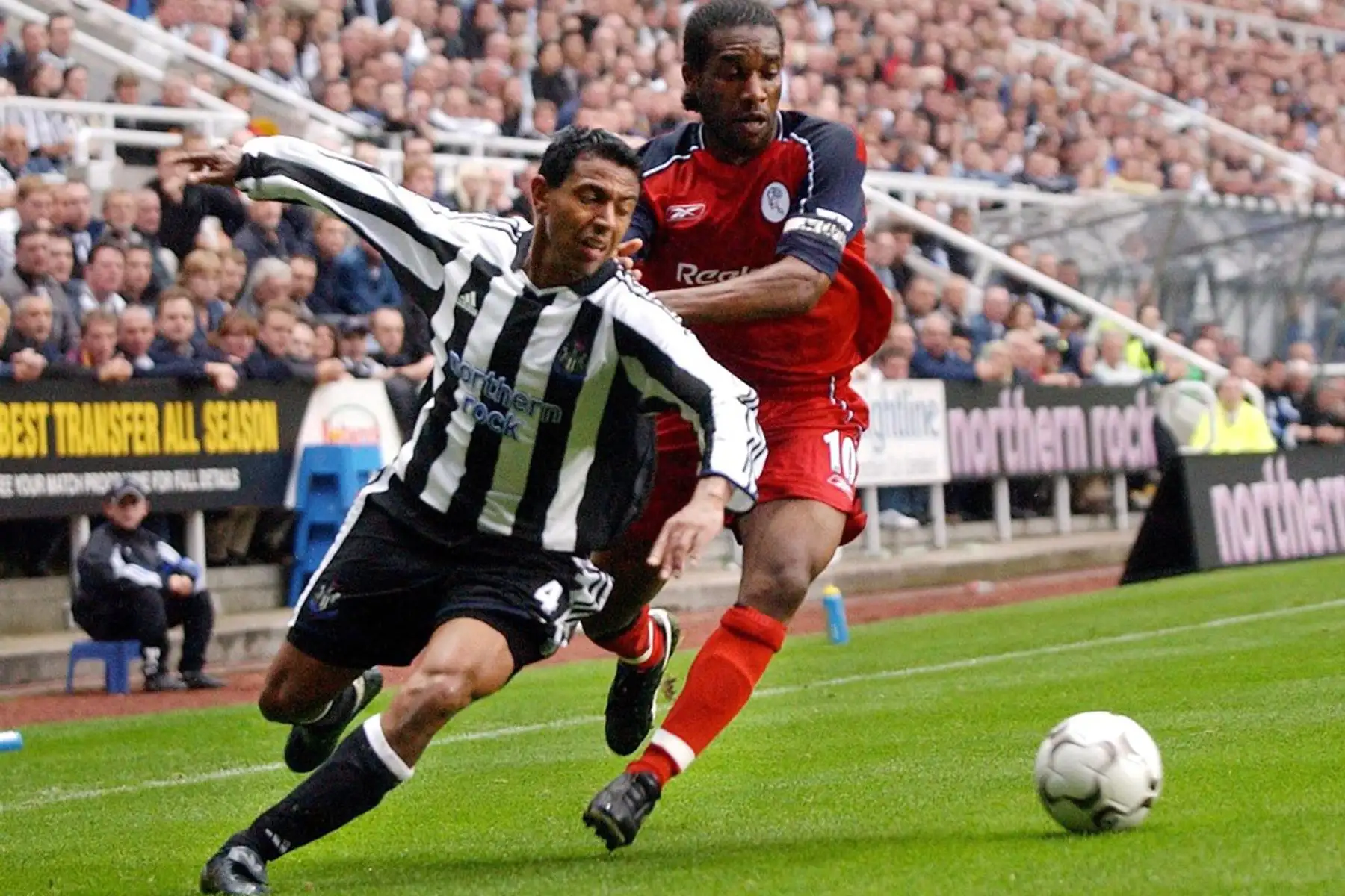 Nolberto Solano  de Newcastle es empujado por Bolton Wanderers Jay Jay Okocha durante su partido de estreno en St James