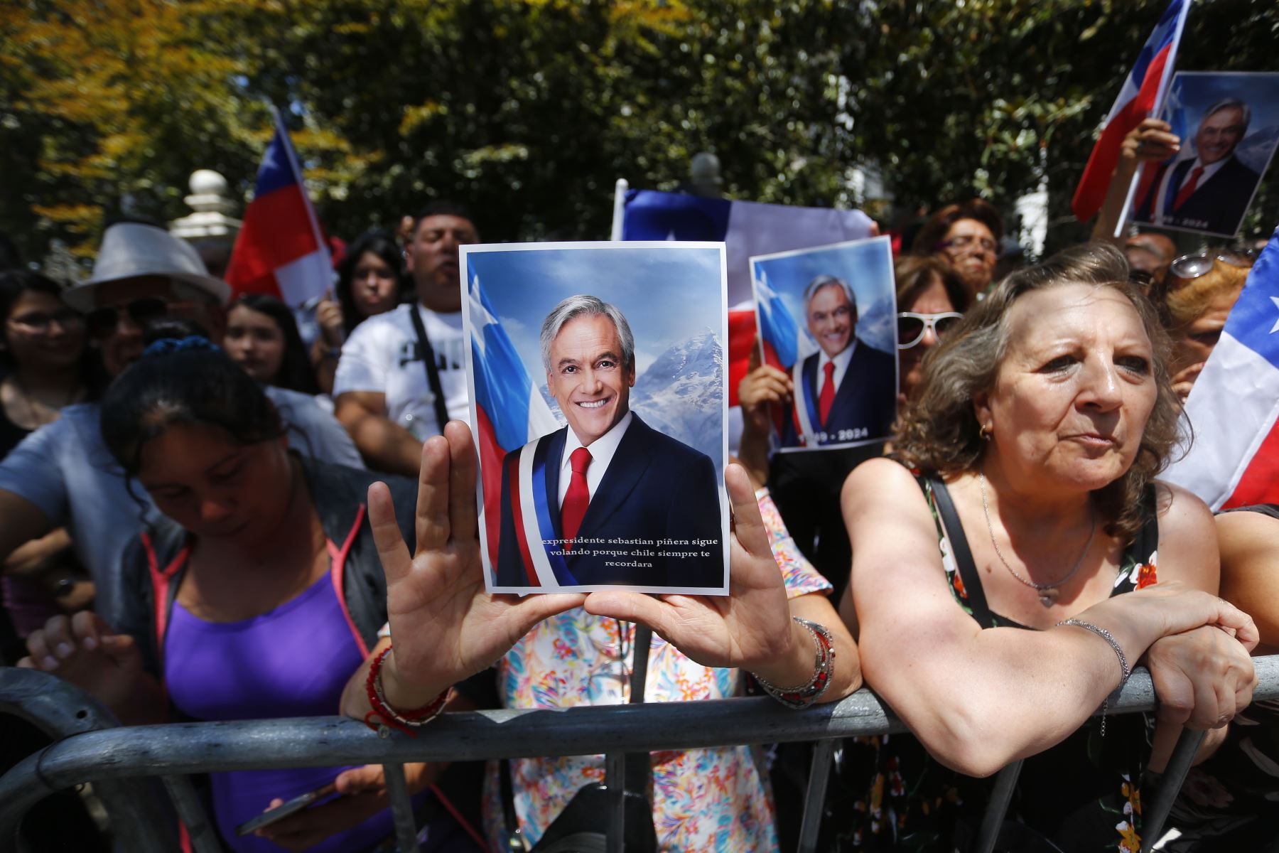 Simpatizantes del fallecido expresidente de Chile Sebastián Piñera esperan el paso de la caravana con el feretro hoy, en las calles de Santiago. Piñera, quien murió en la tarde de ayer en un accidente en el helicóptero que pilotaba, será velado en la antigua sede del Congreso Nacional y el viernes recibirá un funeral de Estado. Foto: ANDINA/ EFE