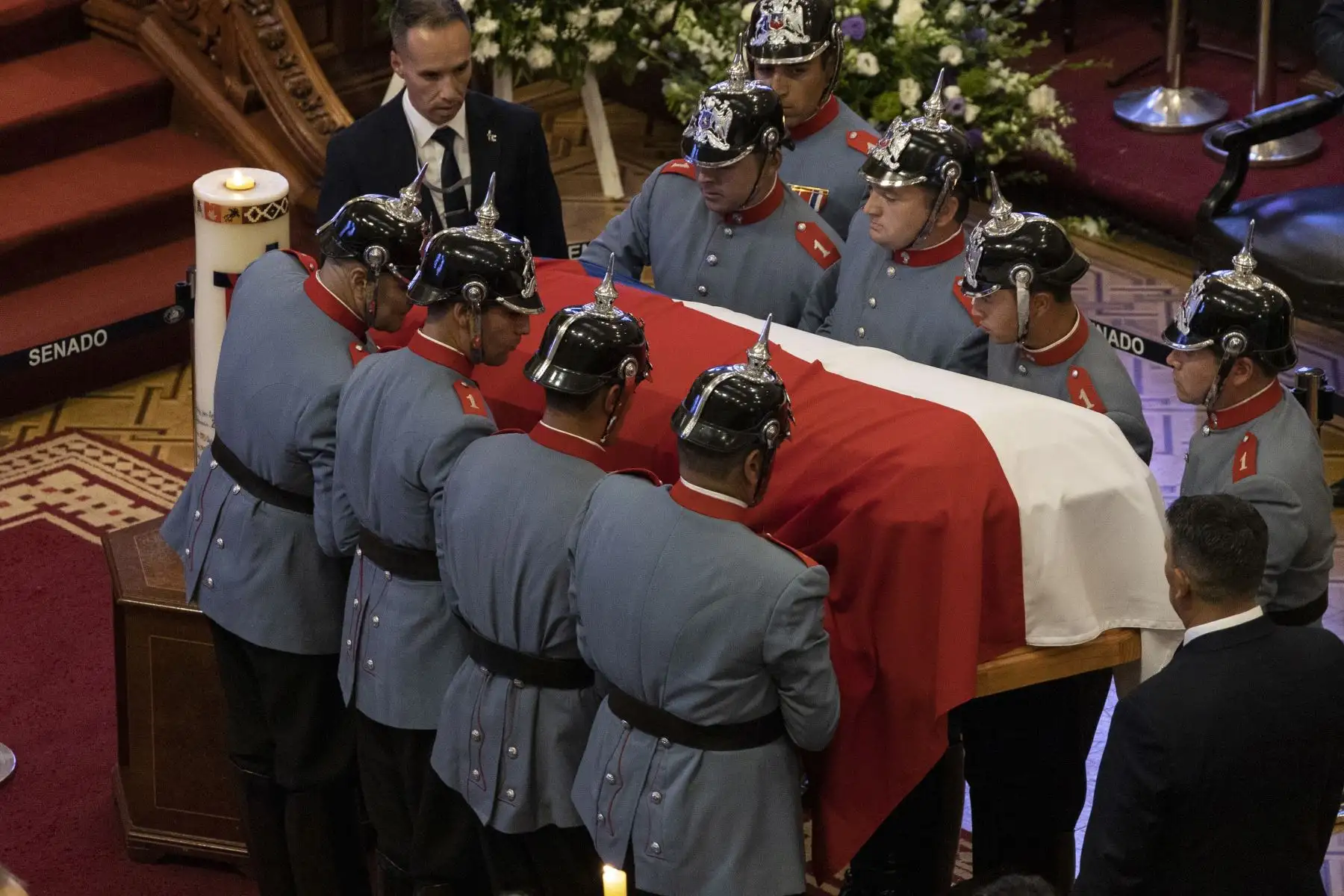 Agentes sostienen el ataúd con el cuerpo del expresidente de Chile Sebastián Piñera hoy, en la antigua sede del Congreso en Santiago. El cortejo fúnebre con los restos del expresidente de Chile Sebastián Piñera,llegaron a la antigua sede del Congreso, en el centro de la capital chilena, donde será velado y recibirá el último adiós de los chilenos previo al funeral de Estado previsto para el viernes. Foto: ANDINA/EFE