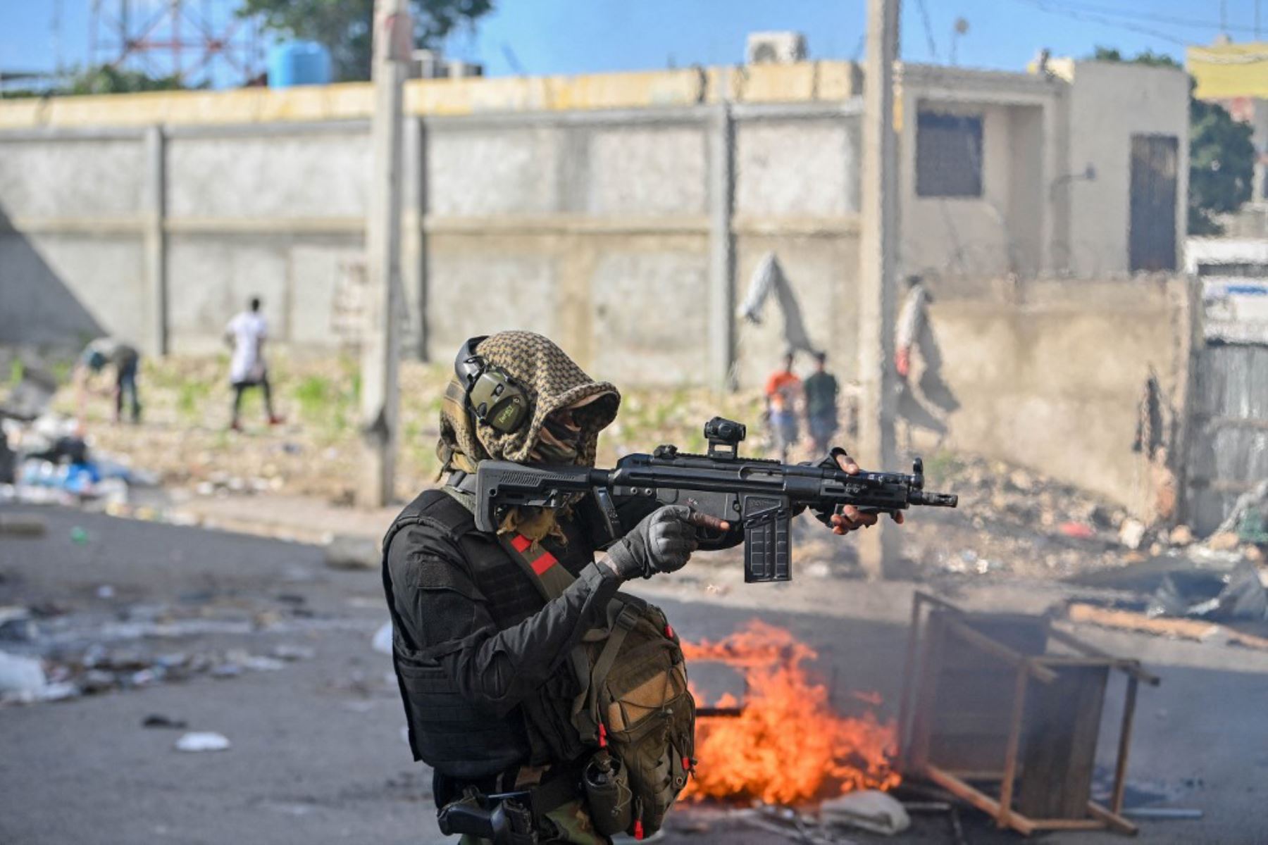 Un policía apunta con un arma a los manifestantes durante una manifestación que pide la renuncia del primer ministro Ariel Henry en Puerto Príncipe. Foto: AFP