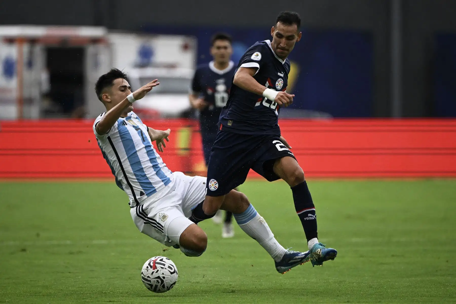 El argentino Pablo Solari y el paraguayo Marcelo Fernández luchan por el balón durante el partido de fútbol del Torneo Preolímpico CONMEBOL Venezuela 2024 entre Argentina y Paraguay en el estadio Brígido Iriarte de Caracas. Foto: ANDINA/AFP