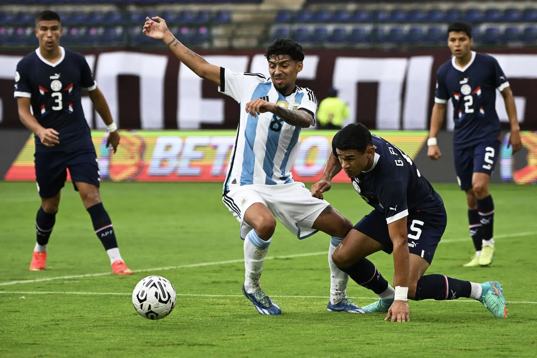 El argentino Cristian Medina  y el paraguayo Gilberto Flores luchan por el balón durante el partido de fútbol del Torneo Preolímpico CONMEBOL Venezuela 2024 entre Argentina y Paraguay en el estadio Brígido Iriarte de Caracas. 
Foto: ANDINA /AFP