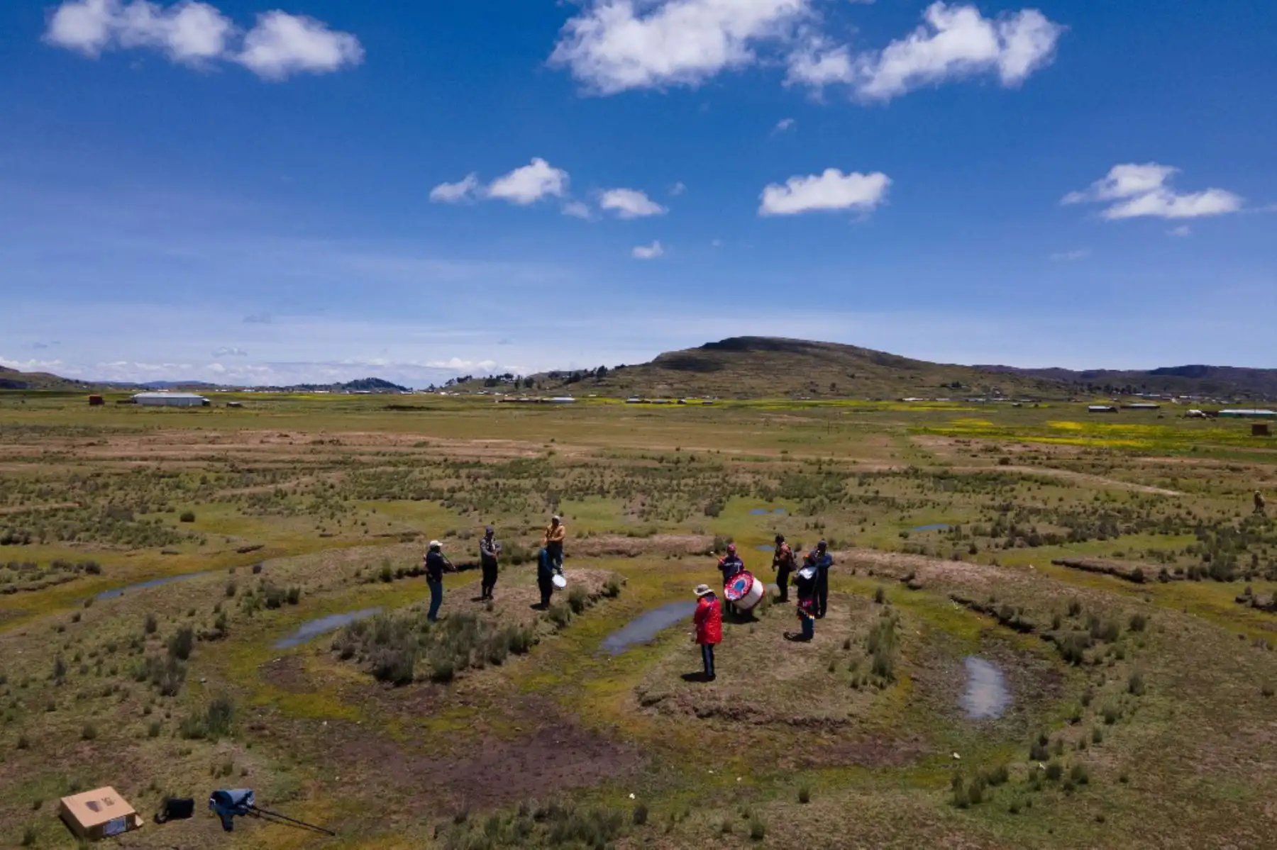 Los campesinos hacen ofrendas a la tierra en un árido Waru Waru, una antigua técnica agrícola, durante una ceremonia en un campo en Acora en Puno a 3,832 m.s.n.m. El  Waru Waru de formas geométricas es una antigua tecnología andina caracterizada por el manejo del agua y el suelo, la selección de semillas, la rotación de cultivos y el microclima, según explica el ingeniero agrónomo Gastón Quispe. Foto AFP