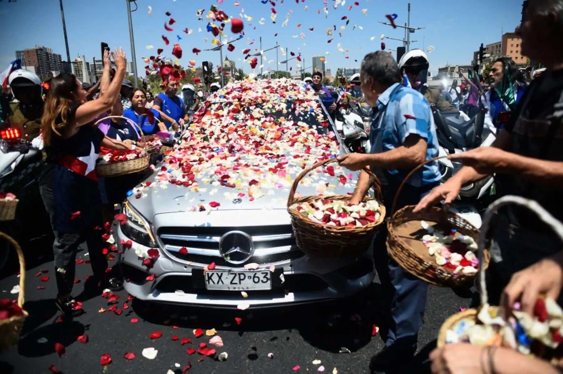 Floristas de la "Pérgola de las Flores" arrojan flores al ataúd del fallecido expresidente de Chile Sebastián Piñera durante su funeral de estado en Santiago. Foto: AFP