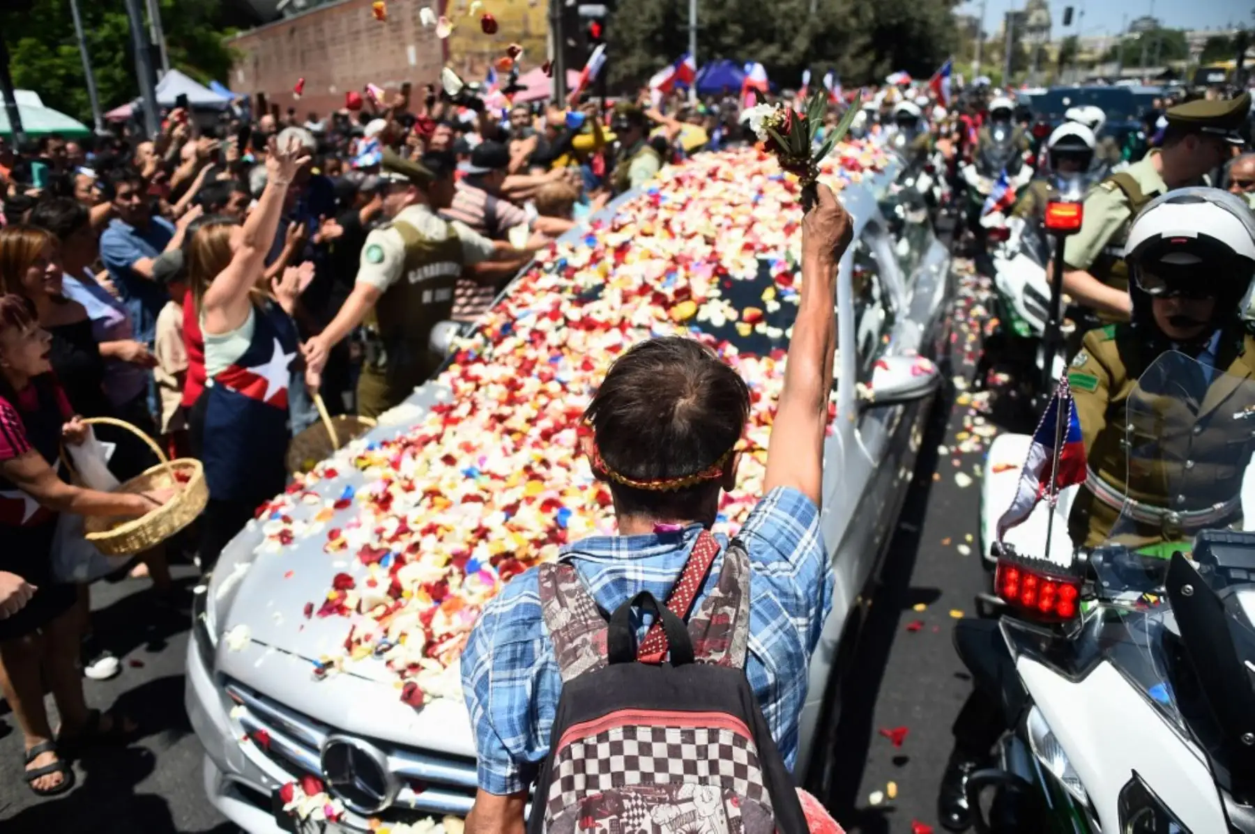 Floristas de la "Pérgola de las Flores" arrojan flores al ataúd del fallecido expresidente de Chile Sebastián Piñera durante su funeral de estado en Santiago. Foto: AFP