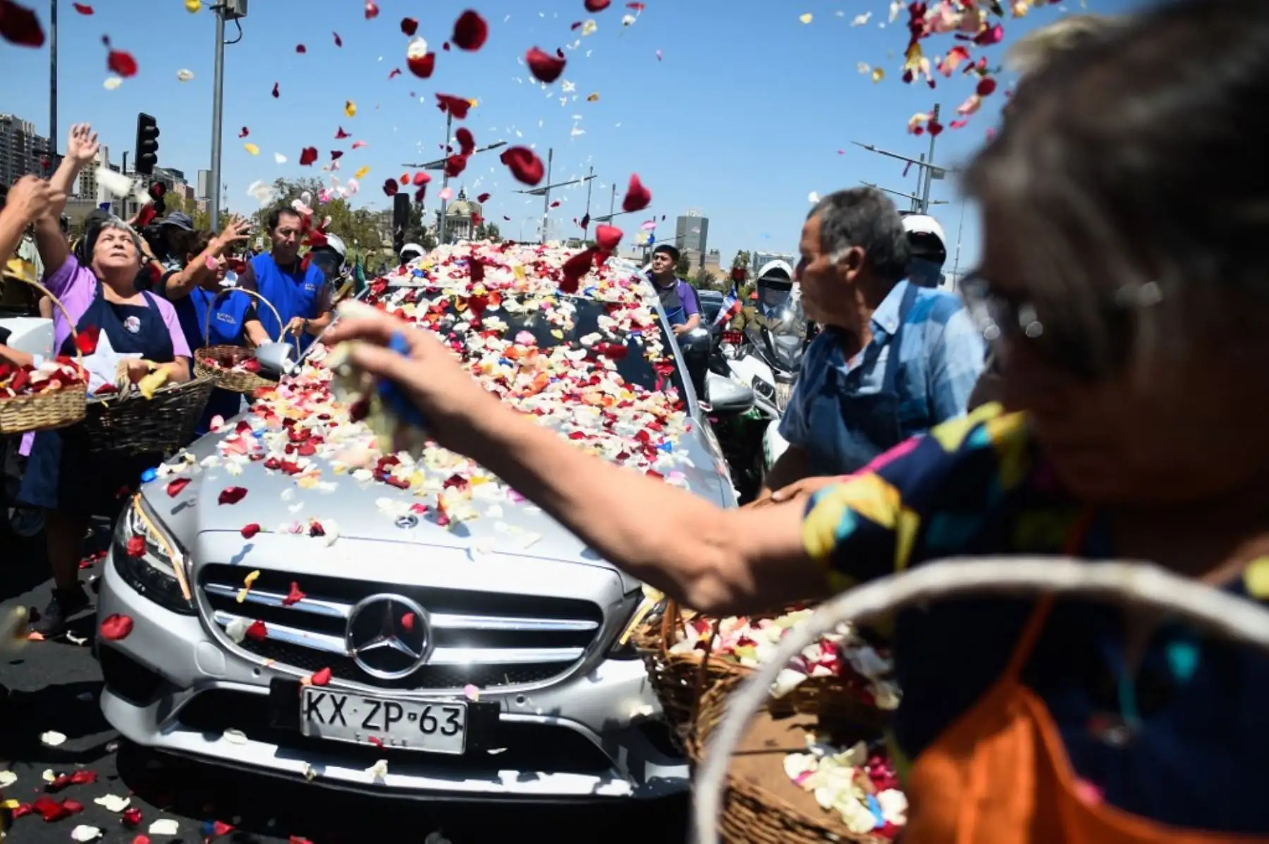 Floristas de la "Pérgola de las Flores" arrojan flores al ataúd del fallecido expresidente de Chile Sebastián Piñera durante su funeral de estado en Santiago. Foto: AFP