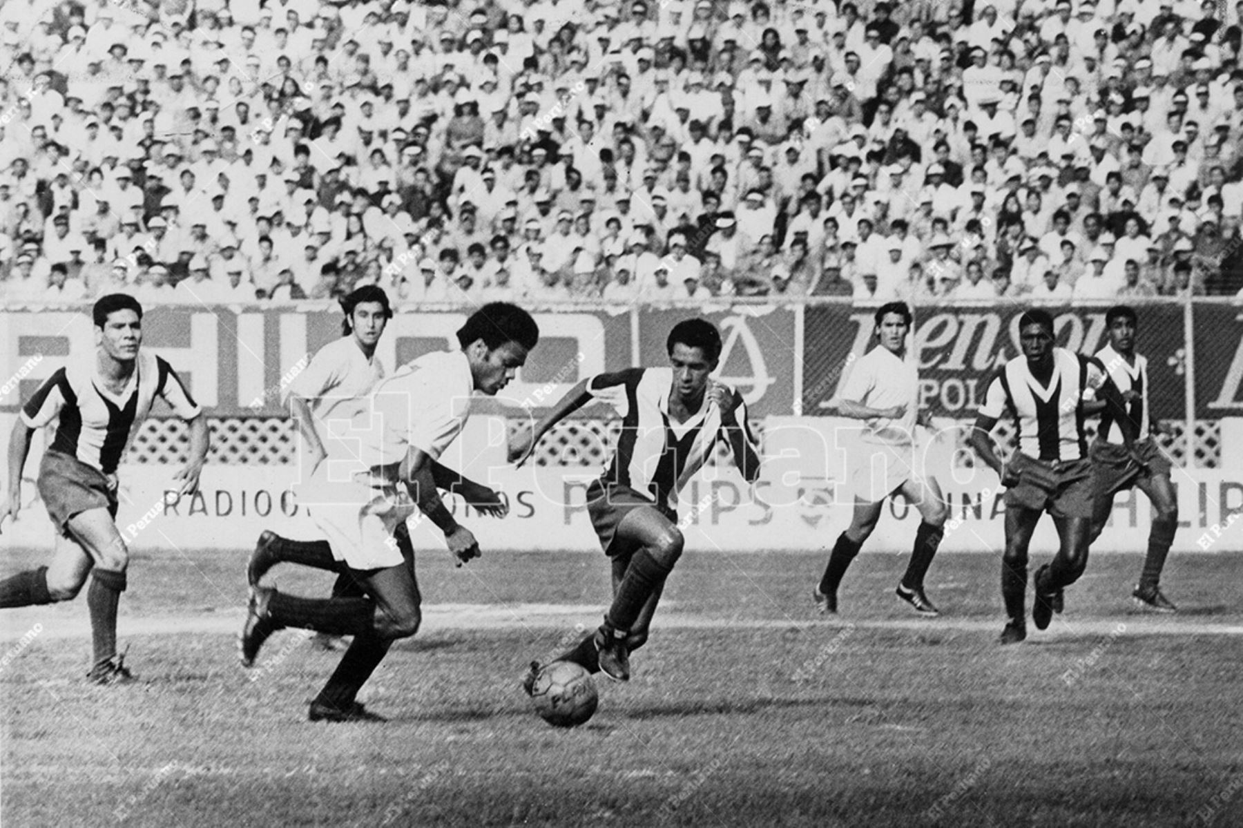 Lima - 12 diciembre 1973 / Juan José Muñante intenta superar a su marcador en el clásico entre Universitario y Alianza Lima que terminó en empate 1-1 en el Estadio Nacional. Foto: Archivo Histórico de El Peruano
