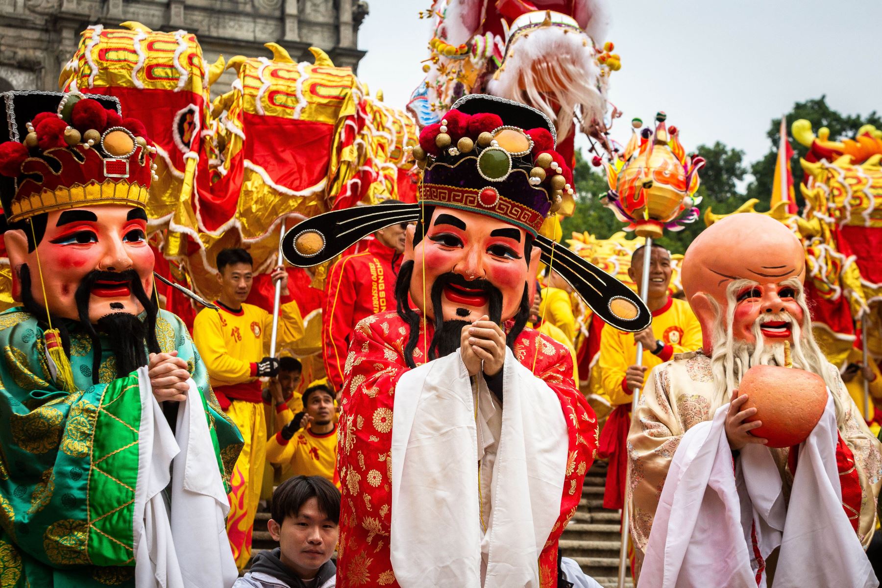 Una marioneta humana de Tsai Shen Yeh, el dios de la riqueza, desfila frente a las ruinas de San Pablo durante las celebraciones en Macao, el primer día del Año Nuevo Lunar del Dragón. Foto: ANDINA/AFP