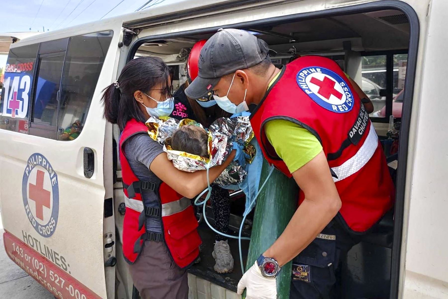 Cruz Roja de Filipinas muestra a los rescatistas brindando atención médica a una niña en el Doctors Community Hospital en Mawab, Davao de Oro, luego de su rescate casi 60 horas después de que un deslizamiento de tierra azotara una mina de oro. Pueblo en el sur de Filipinas. Foto: ANDINA/AFP