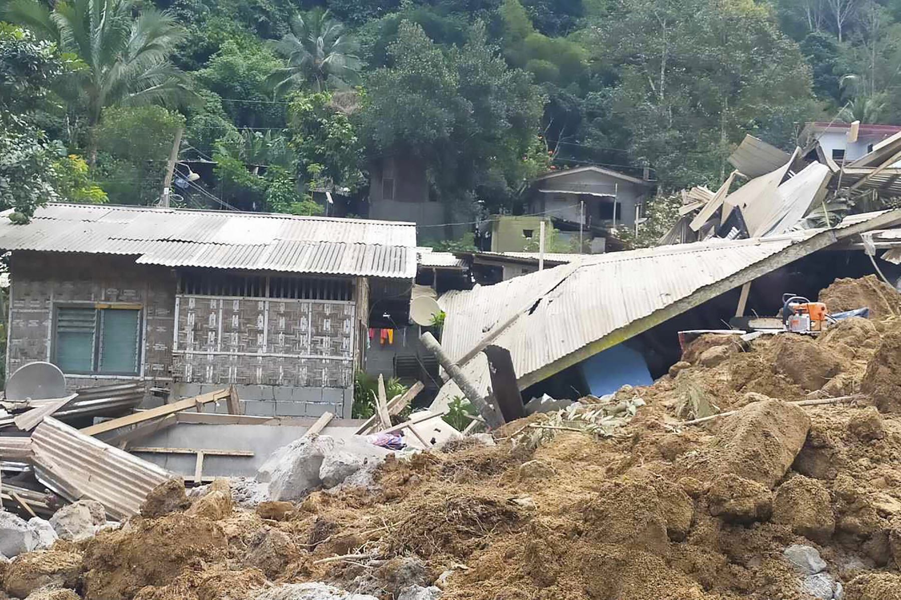 Oficina del Jefe Provincial de Bomberos (OPFM) de Davao de Oro muestra propiedades dañadas en el lugar de un deslizamiento de tierra en Maco, Davao de Oro. Un deslizamiento de tierra provocado por la lluvia cubrió dos autobuses y casas en una región montañosa del sur de Filipinas. Foto. ANDINA/ AFP