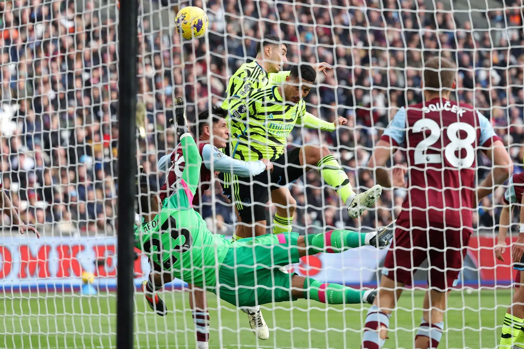 El defensor francés del Arsenal William Saliba  dirige a casa el gol inicial pasando al portero francés del West Ham United Alphonse Areola durante el partido de fútbol de la Premier League inglesa entre West Ham United y Arsenal en el London Stadium, en Londres. Foto: ANDINA/AFP