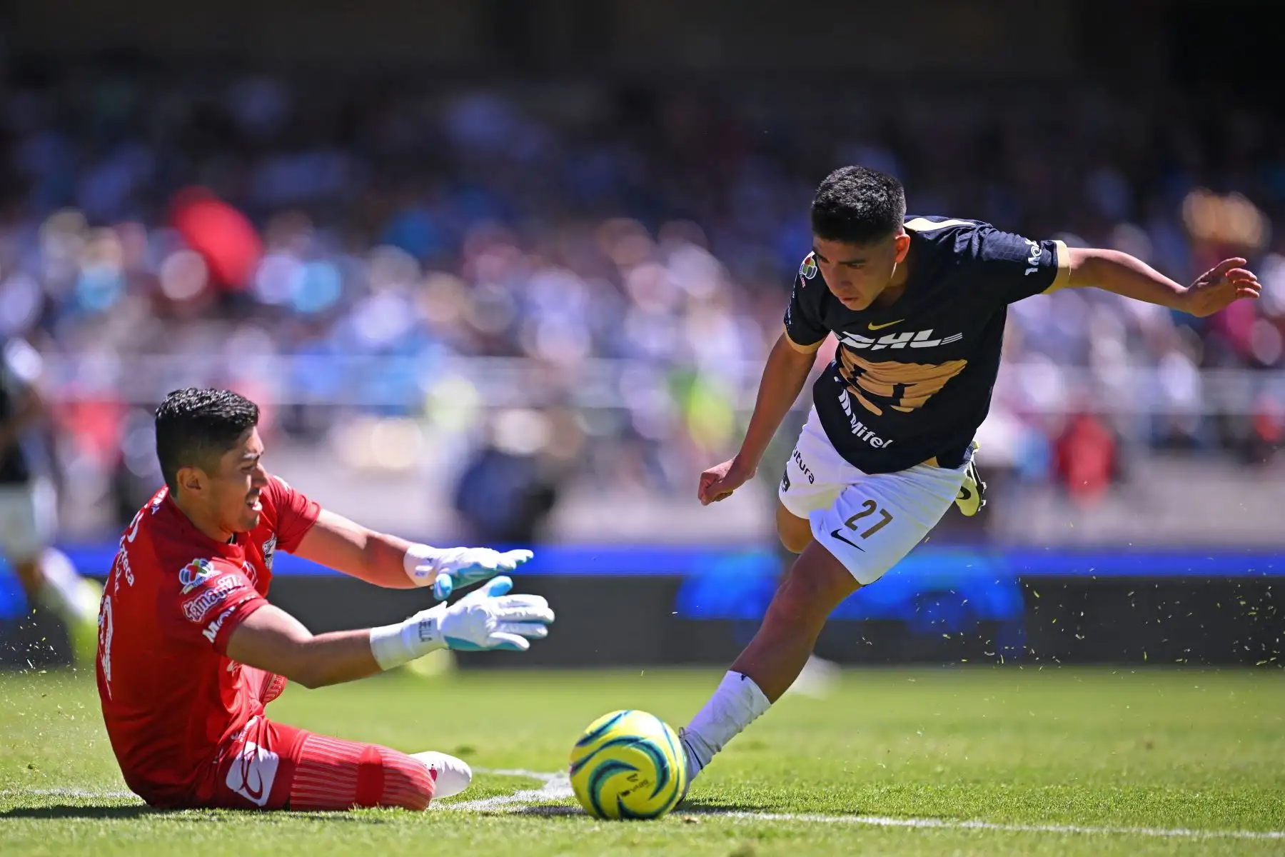 Piero Quispe  de Puma y el portero de Puebla Jesús Rodríguez  luchan por el balón durante su partido de fútbol del torneo Clausura mexicano 2024 en el estadio Olímpico Universitario de la Ciudad de México.
Foto: AFP