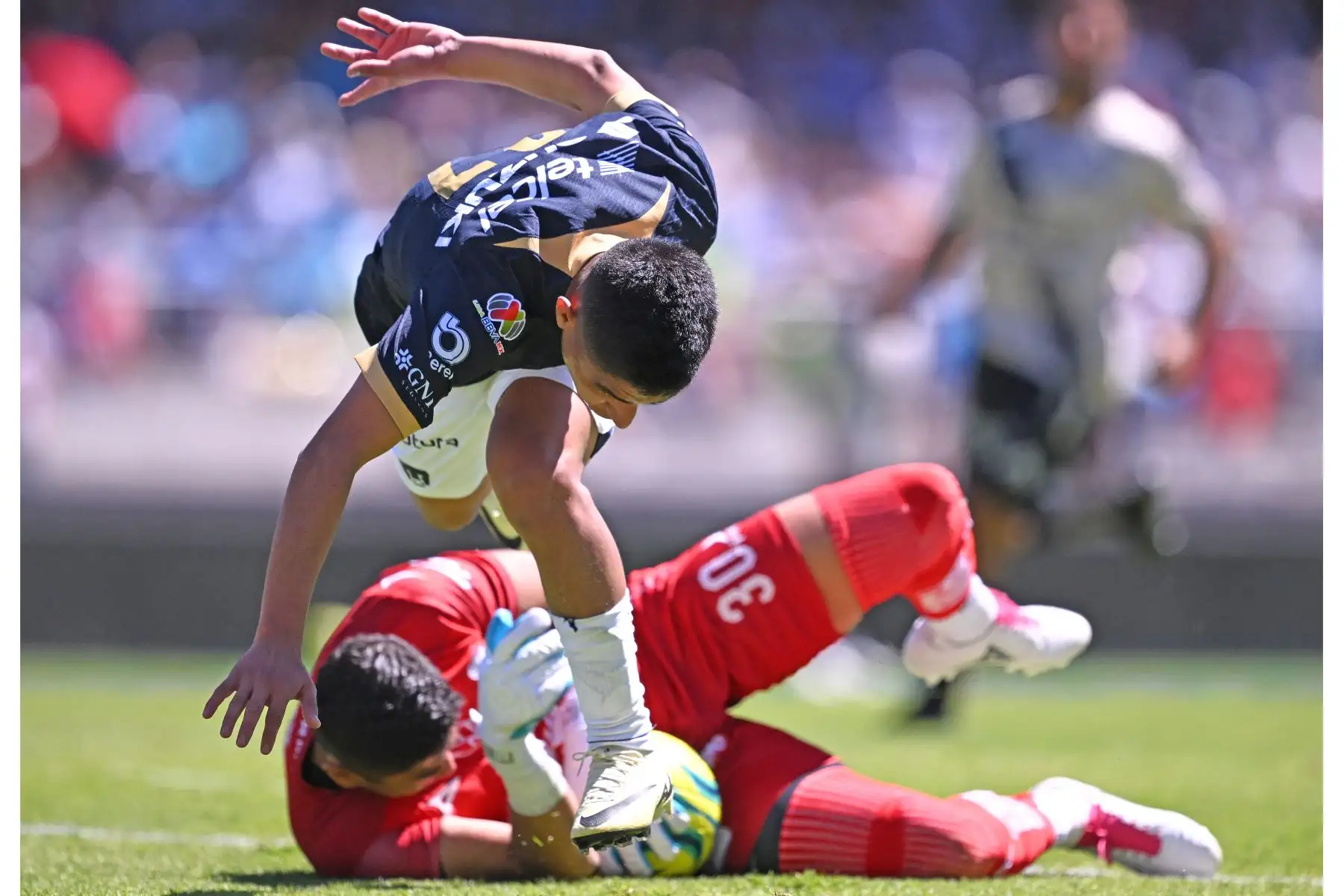 Piero Quispe de Puma y el portero de Puebla Jesús Rodríguez (atrás) luchan por el balón durante su partido de fútbol del torneo Clausura mexicano 2024 en el estadio Olímpico Universitario de la Ciudad de México.
Foto: AFP