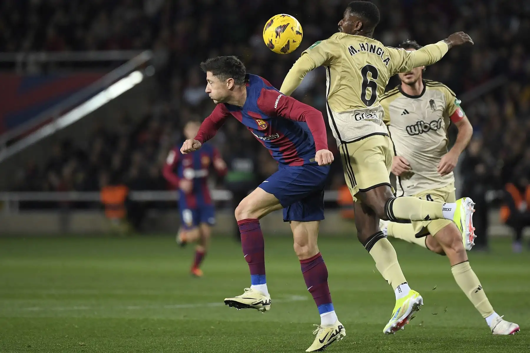 El delantero polaco del Barcelona,  Robert Lewandowski lucha por el balón con el centrocampista camerunés del Granada #06 Martin Hongla durante el partido de fútbol de la liga española entre el FC Barcelona y el Granada FC en el Estadi Olimpic Lluis Companys de Barcelona.
Foto: AFP