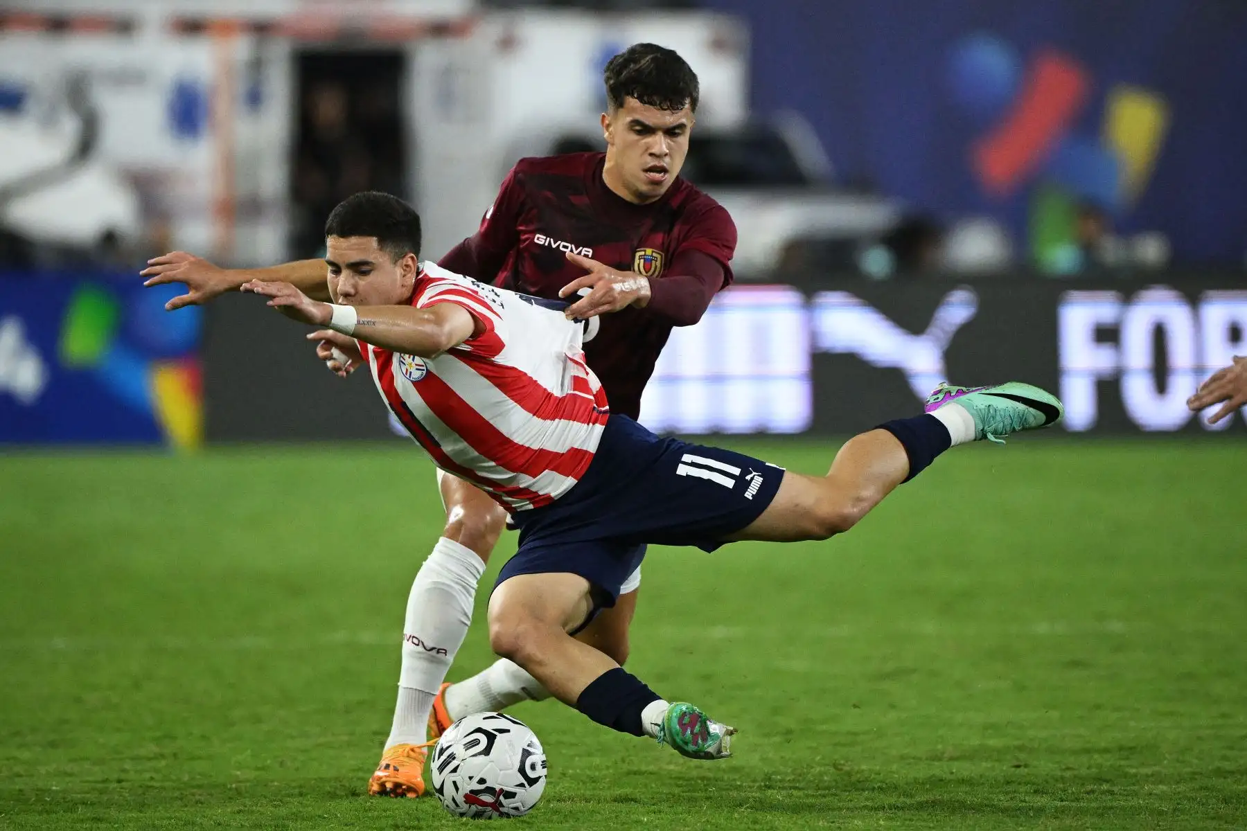 El venezolano Rafael Uzcategui y el paraguayo Enso González  luchan por el balón durante el partido de fútbol del Torneo Preolímpico CONMEBOL Venezuela 2024 entre Paraguay y Venezuela en el estadio Brígido Iriarte de Caracas.
Foto: AFP