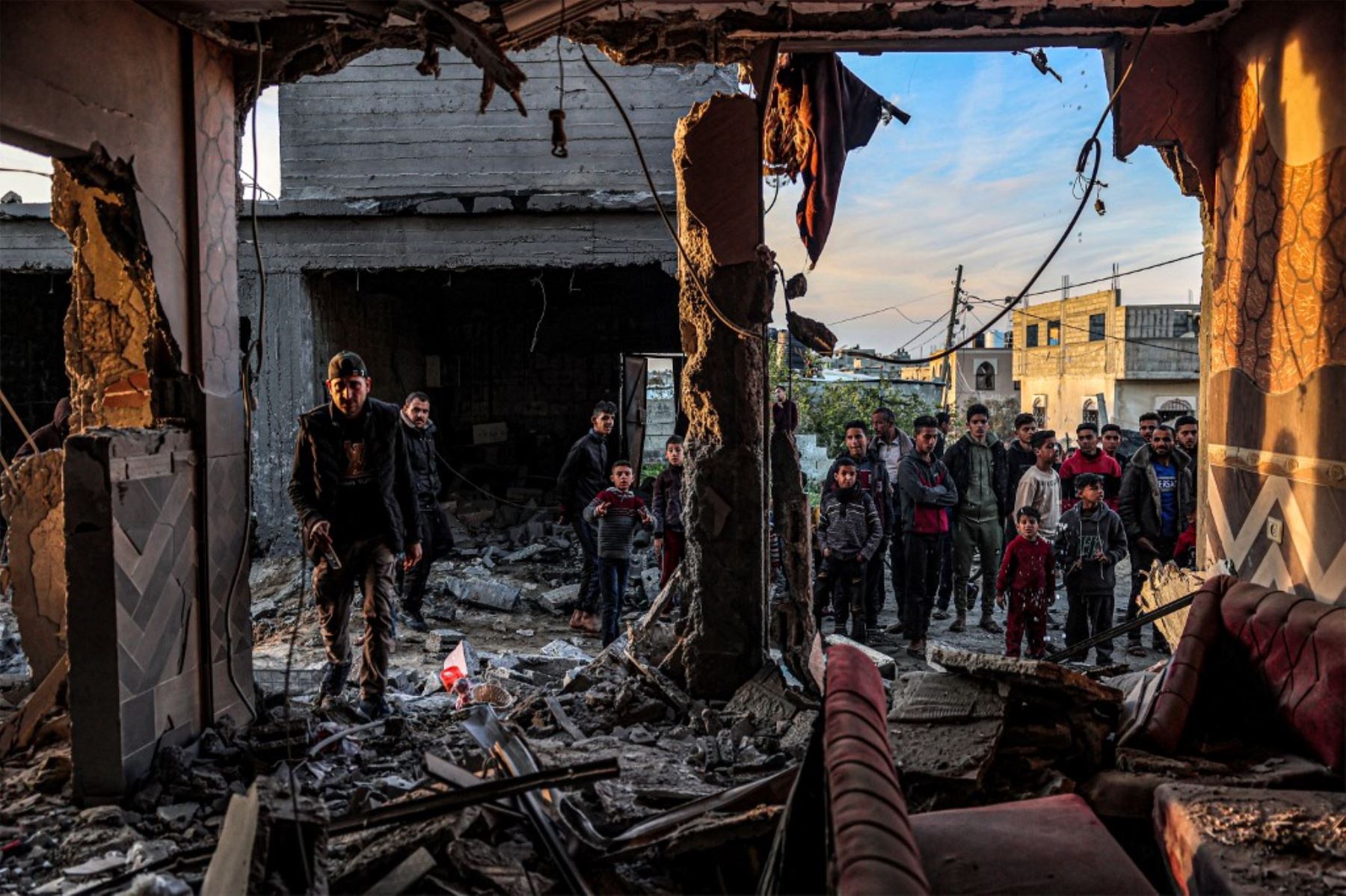 La gente inspecciona escombros y escombros en un edificio gravemente dañado por los bombardeos israelíes, en Rafah, en el sur de la Franja de Gaza. Foto: AFP