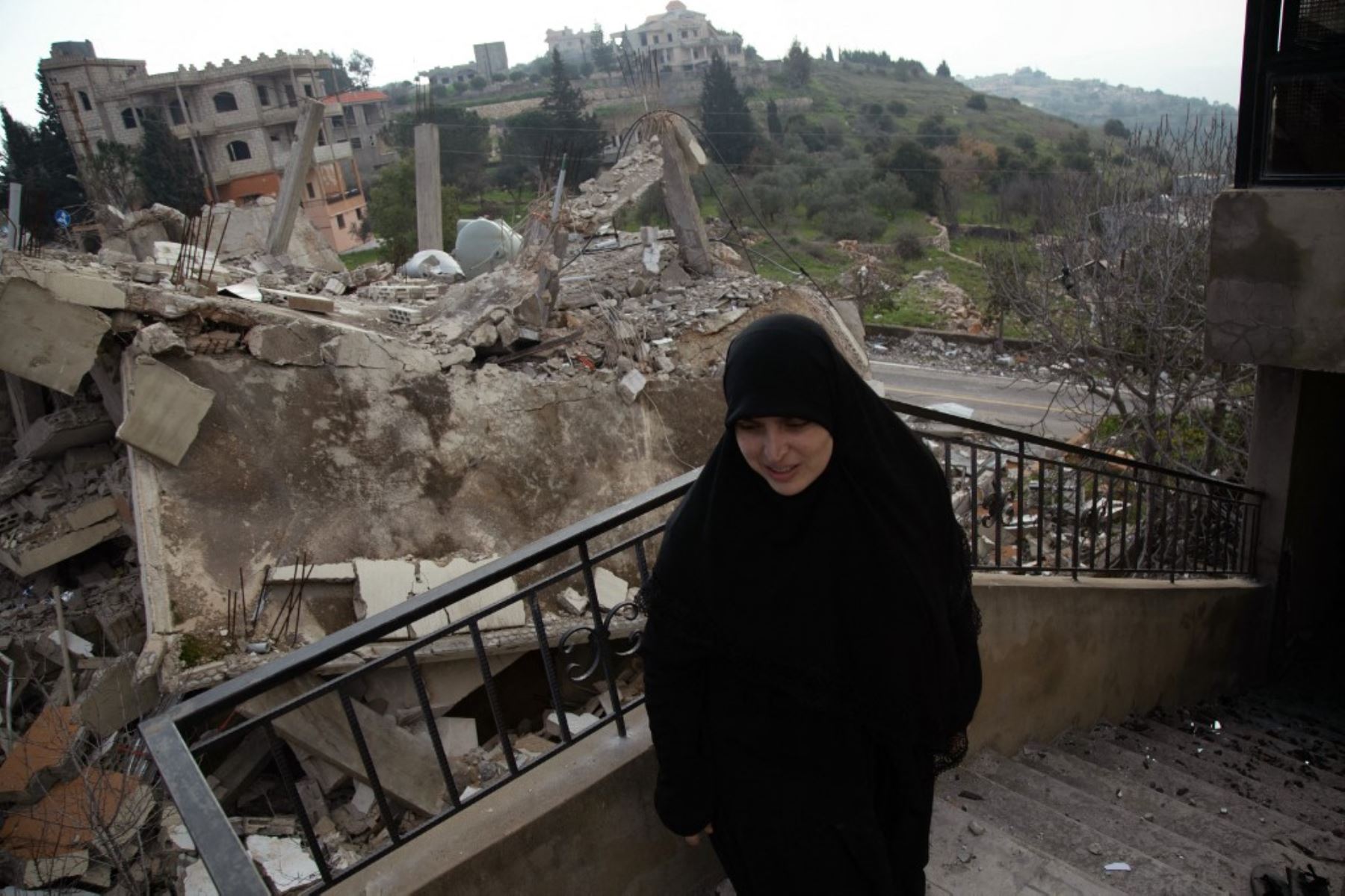 Una mujer inspecciona los daños causados ​​por los ataques israelíes en la aldea de Houla, en el sur del Líbano, cerca de la frontera. Foto: AFP