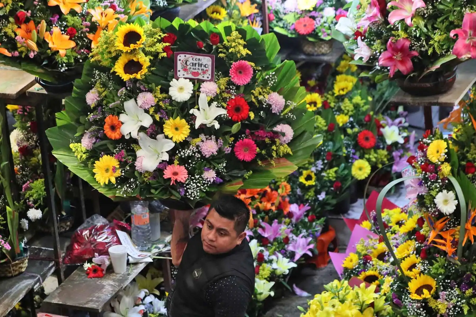 Personas compran ramos de flores en el mercado Jamaica durante los preparativos para San Valentín, en Ciudad de México. Foto: AFP