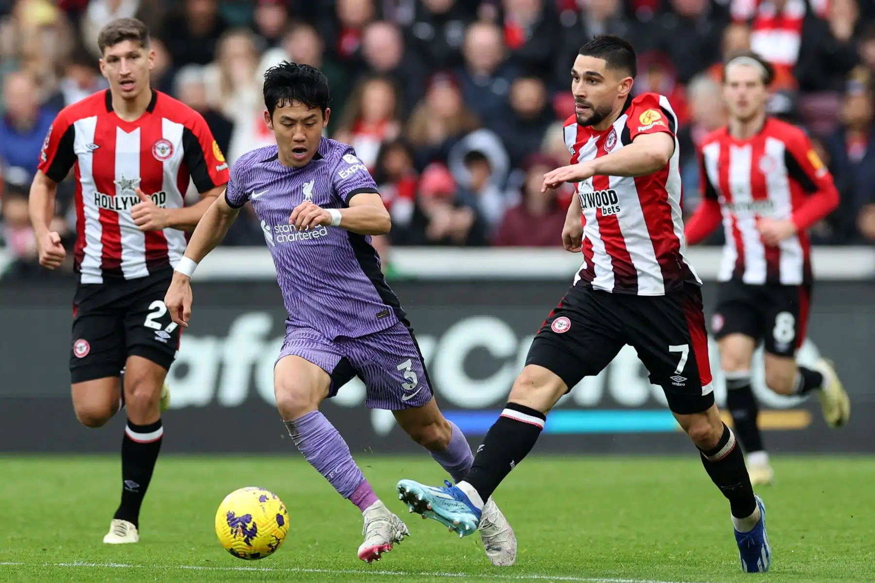 El centrocampista japonés del Liverpool Wataru Endo  compite con el delantero francés del Brentford Neal Maupay durante el partido de fútbol de la Premier League inglesa entre Brentford y Liverpool en el Gtech Community Stadium de Londres. Foto: ANDINA/AFP