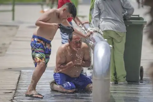 Sofocado por el calor, un veraneante no dudó en meterse de cuerpo entero en la zona destinada para sacarse la arena de los pies en la playa Agua Dulce, Chorrillos. Foto: ANDINA/Andrés Valle