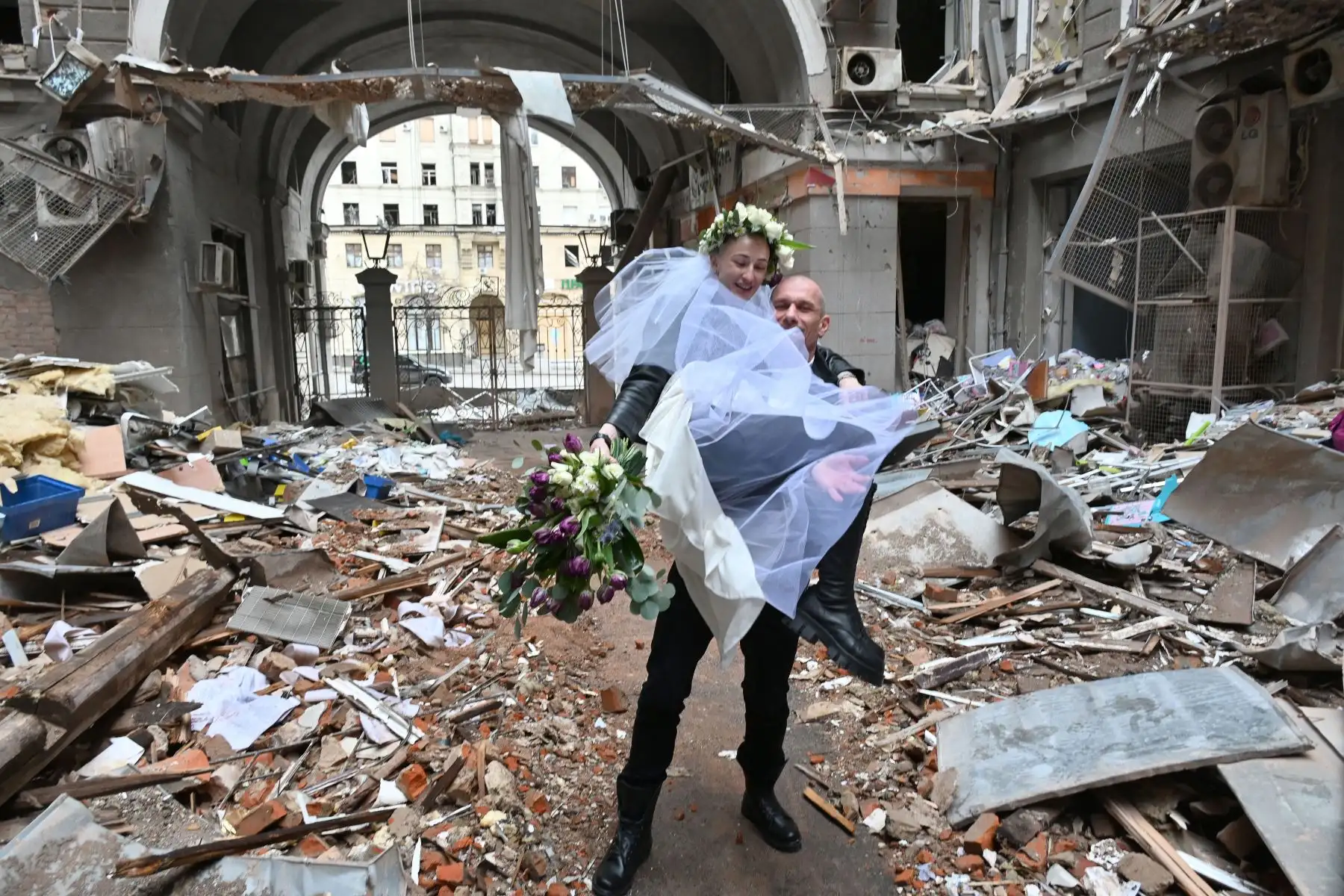 Los recién casados, voluntarios médicos, enfermera en una clínica de oncología y médico antes del comienzo de la invasión rusa de Ucrania, Nastya Gracheva y Anton Sokolov, posan para una fotografía en un patio en ruinas de un complejo comercial y de oficinas en el centro de Kharkiv. Foto: AFP