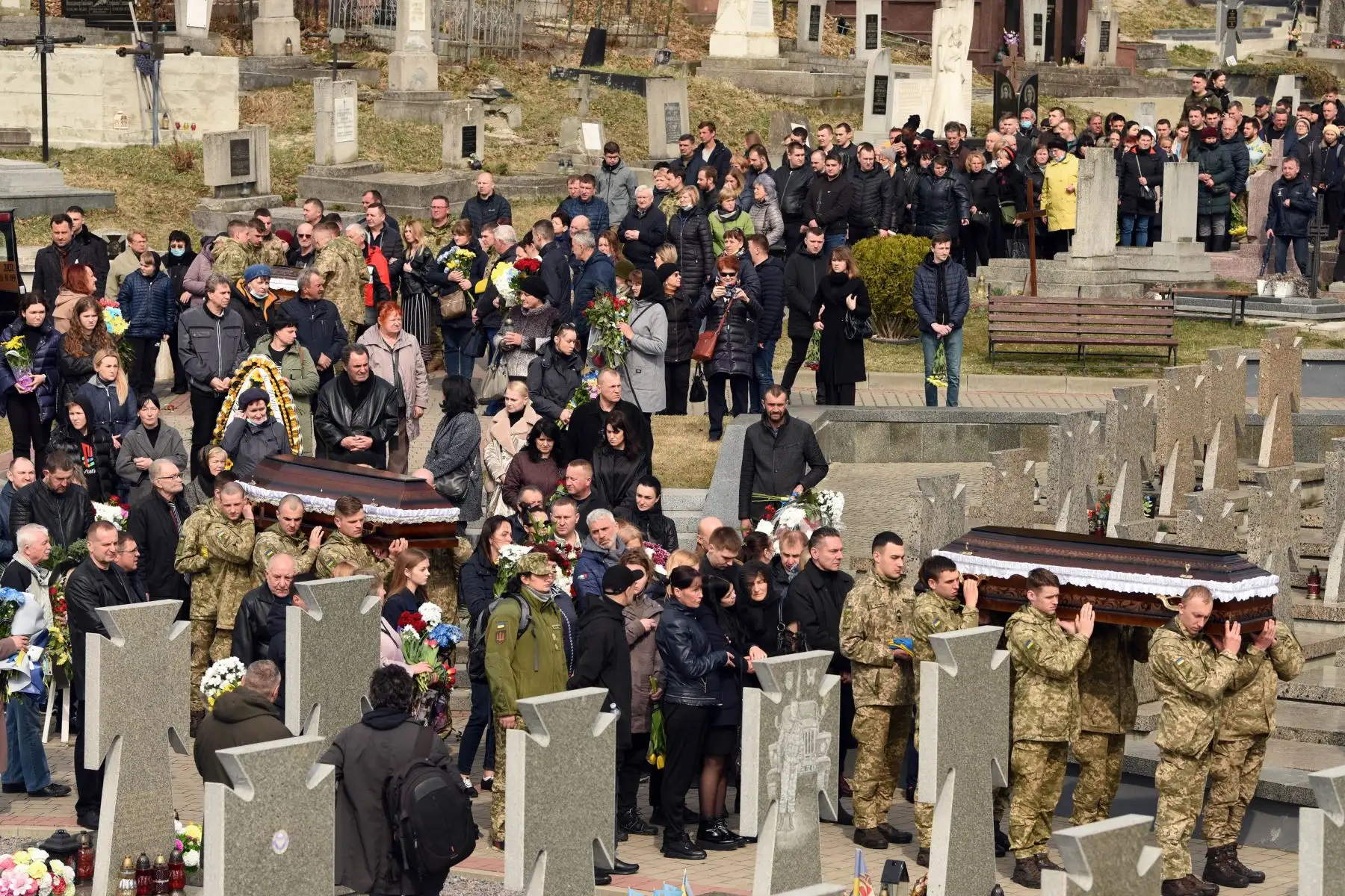 Soldados ucranianos cargan ataúdes con los cuerpos de soldados en el cementerio de Lychakiv en Ucrania. Foto: AFP